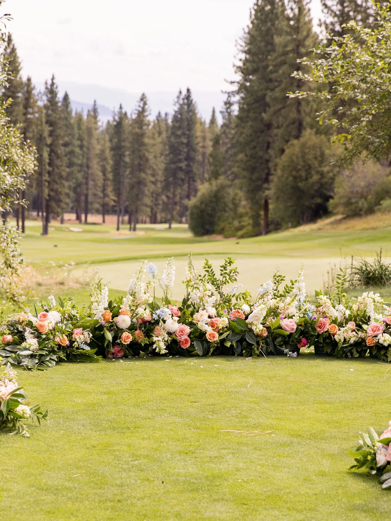 Outdoor wedding ceremony setup with lush floral arrangements at a mountain golf course venue in Northern Nevada.