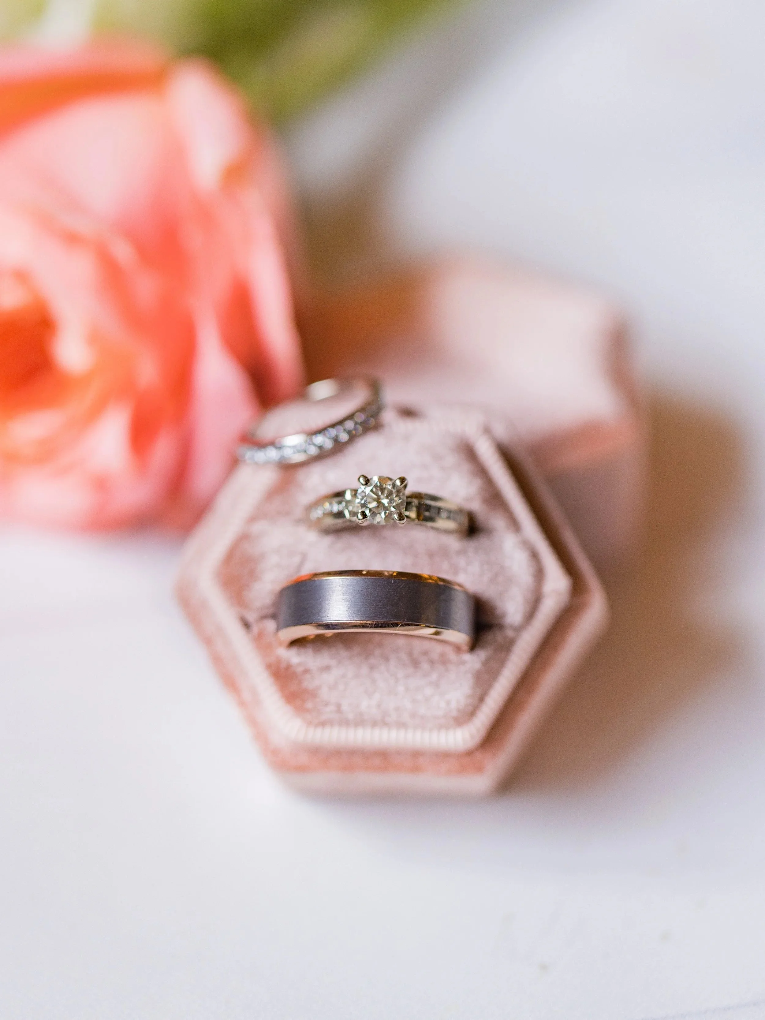 Wedding rings in a blush velvet ring box with soft romantic florals at a Northern Nevada wedding.