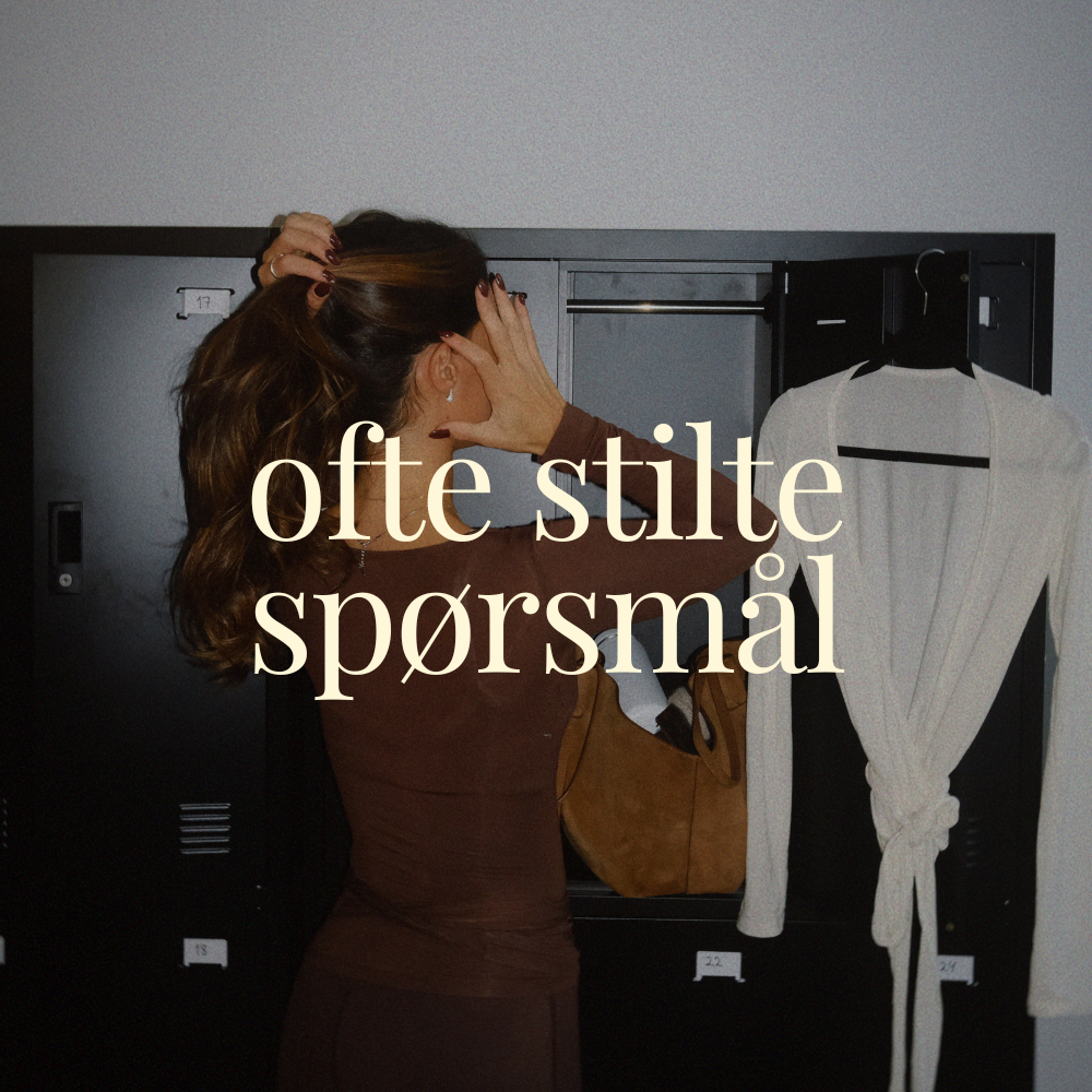 A woman standing in front of lockers, holding her head with one hand and adjusting her hair with the other. There is a white tied cardigan hanging in a locker and a brown bag inside the locker.