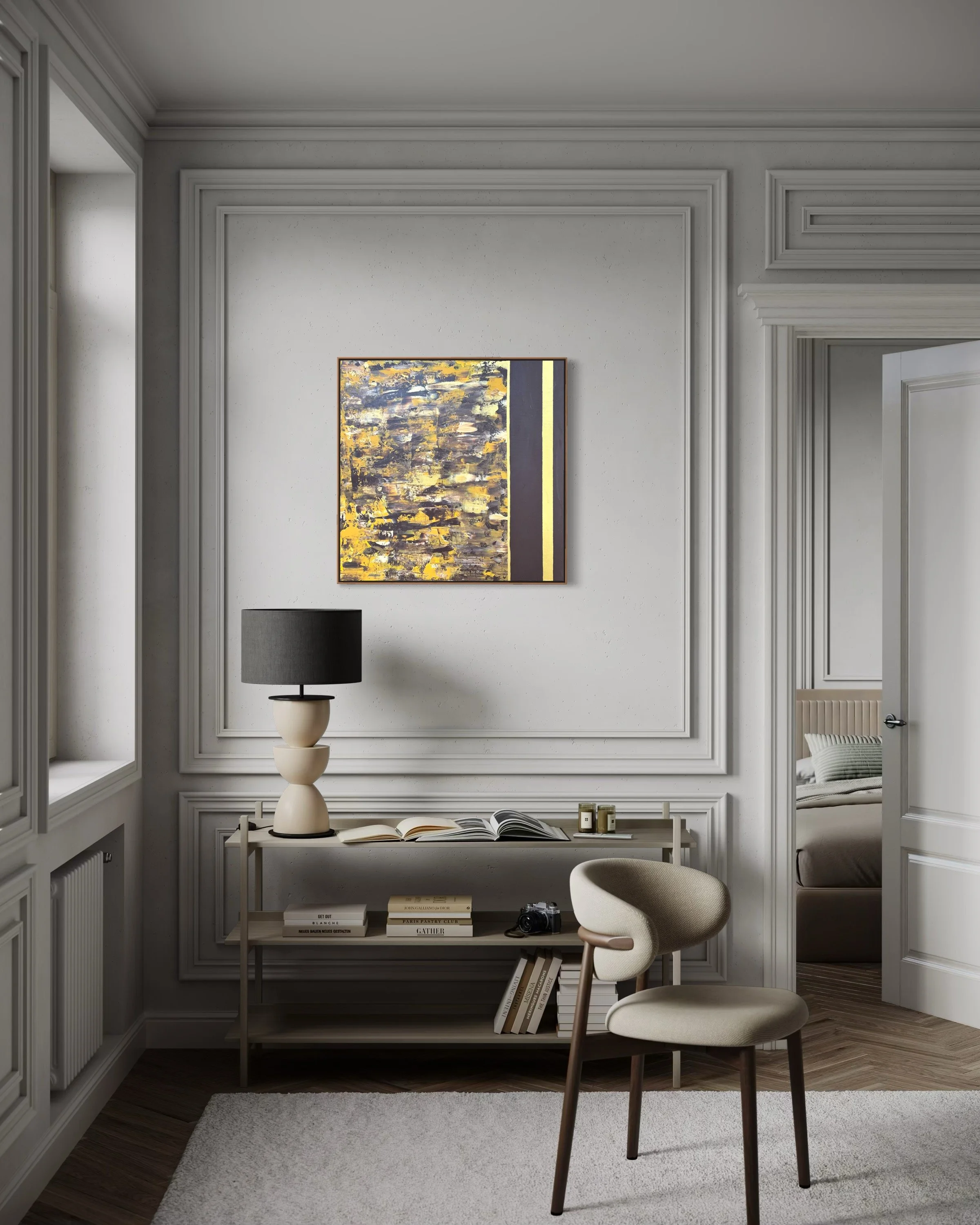 Intérieur d'une pièce élégante avec un mur blanc orné de moulures, une peinture abstraite aux couleurs jaunes, noires et grises, une table basse avec un livre ouvert, un vase, une photo, un fauteuil beige et une lampe à abat-jour noir, avec une porte