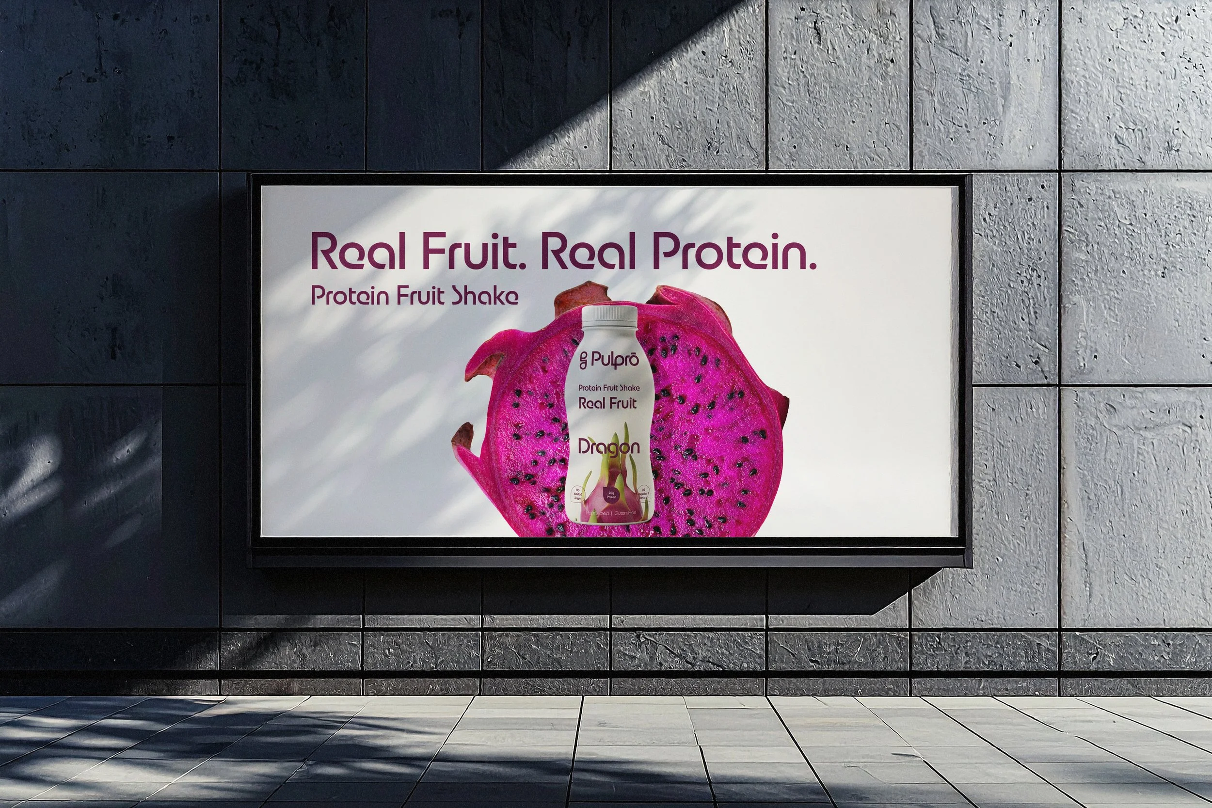 Billboard advertisement for a protein fruit shake with a dragon fruit image and text: "Real Fruit. Real Protein." and product branding.