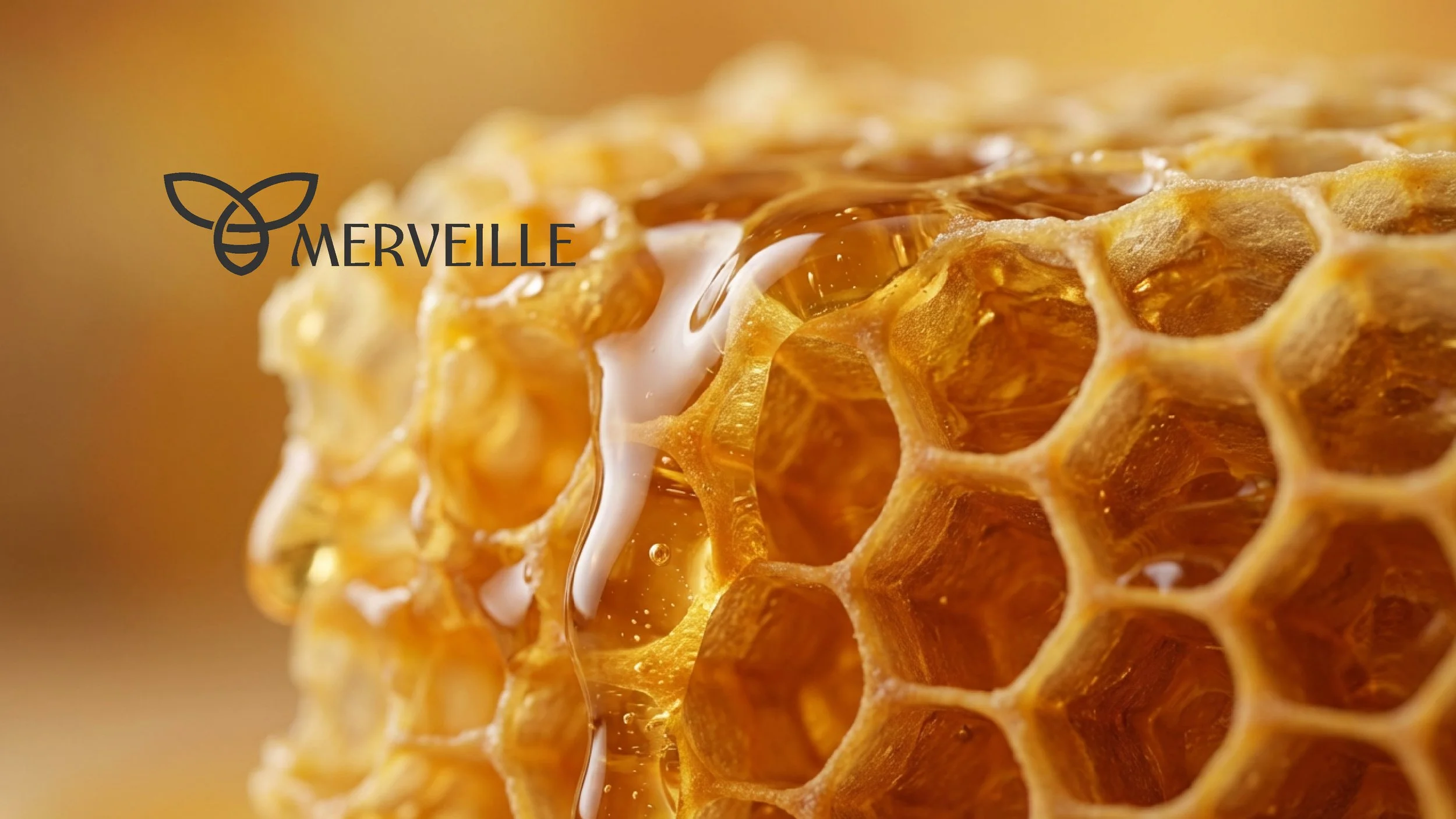 Close-up of a honeycomb with honey dripping from it, with a blurred background and the Merveille logo and name overlayed.