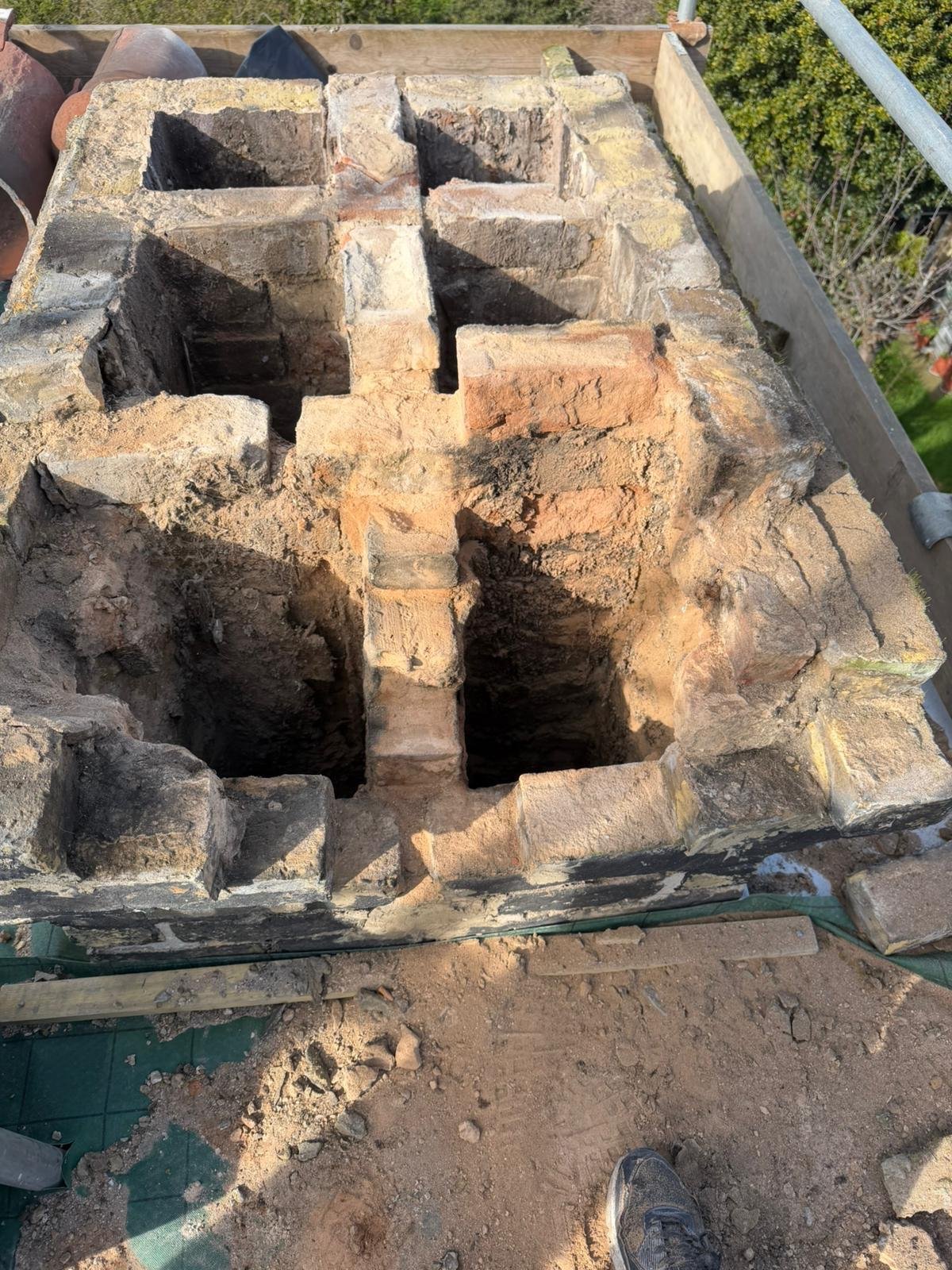 Close-up of a brick kiln or oven under construction, with hollow brick structures and dirt surrounding it.