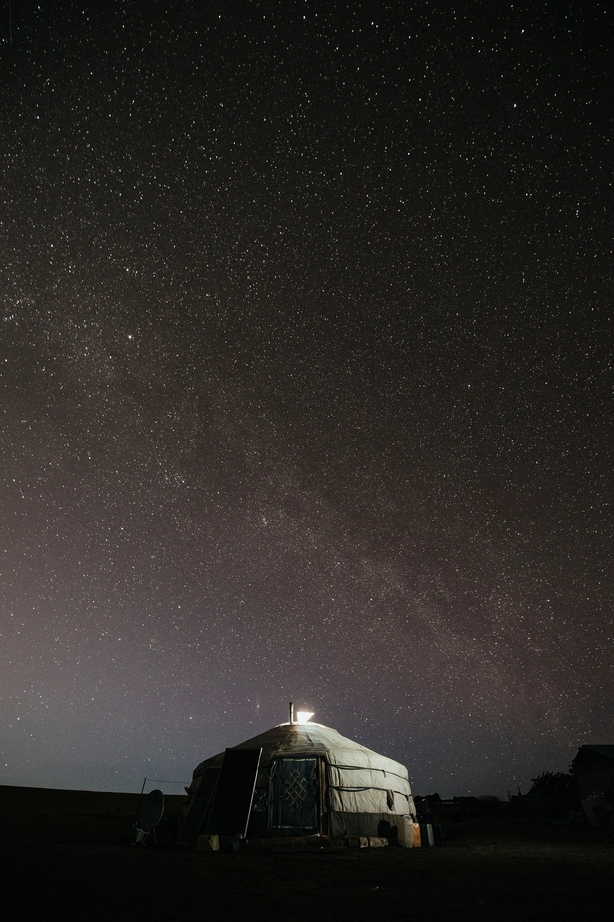 Une yourte sous un ciel étoilé avec la voie lactée visible.