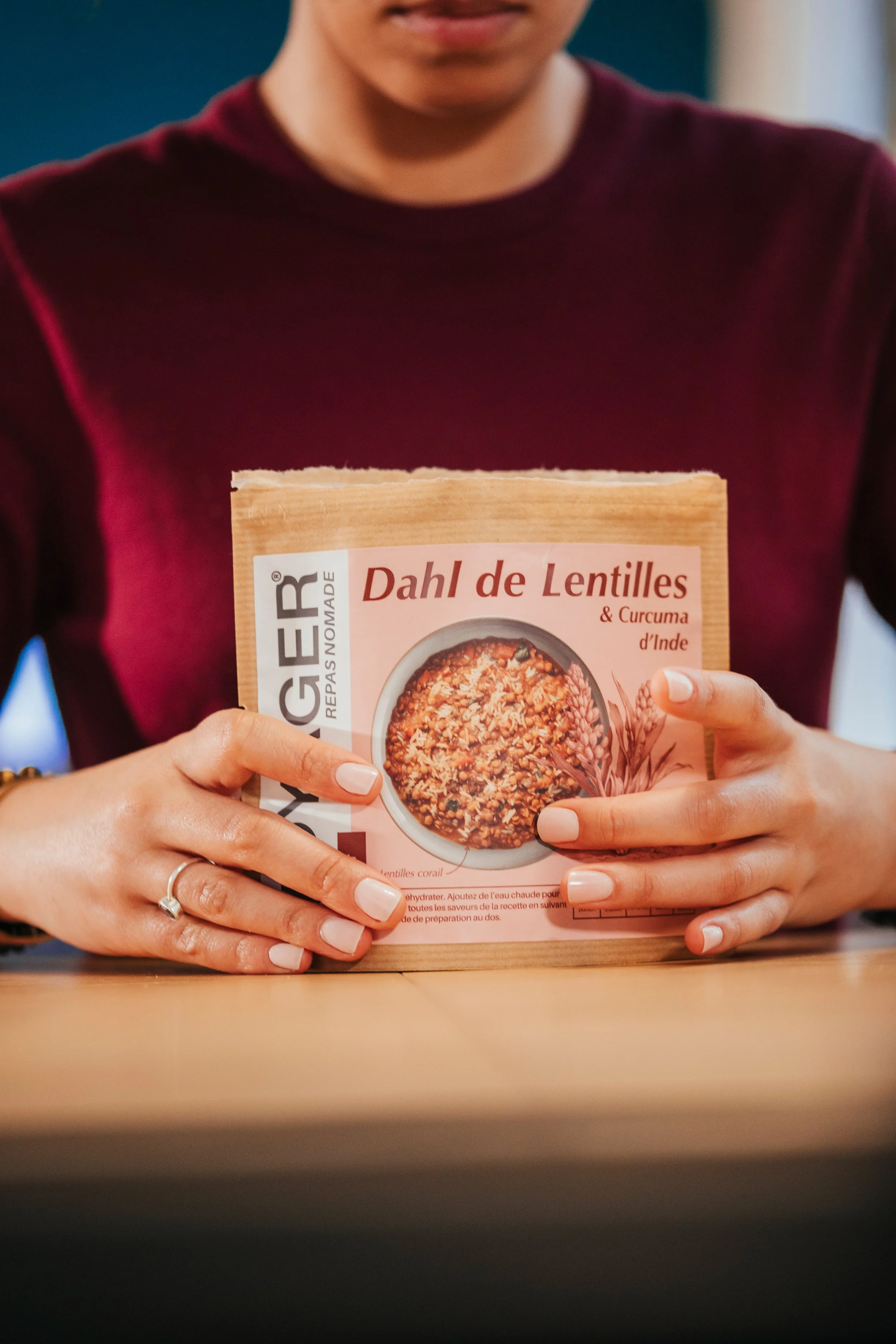 Person tenant un paquet de repas instantané 'Dahl de Lentilles & Curcuma d'Inde'