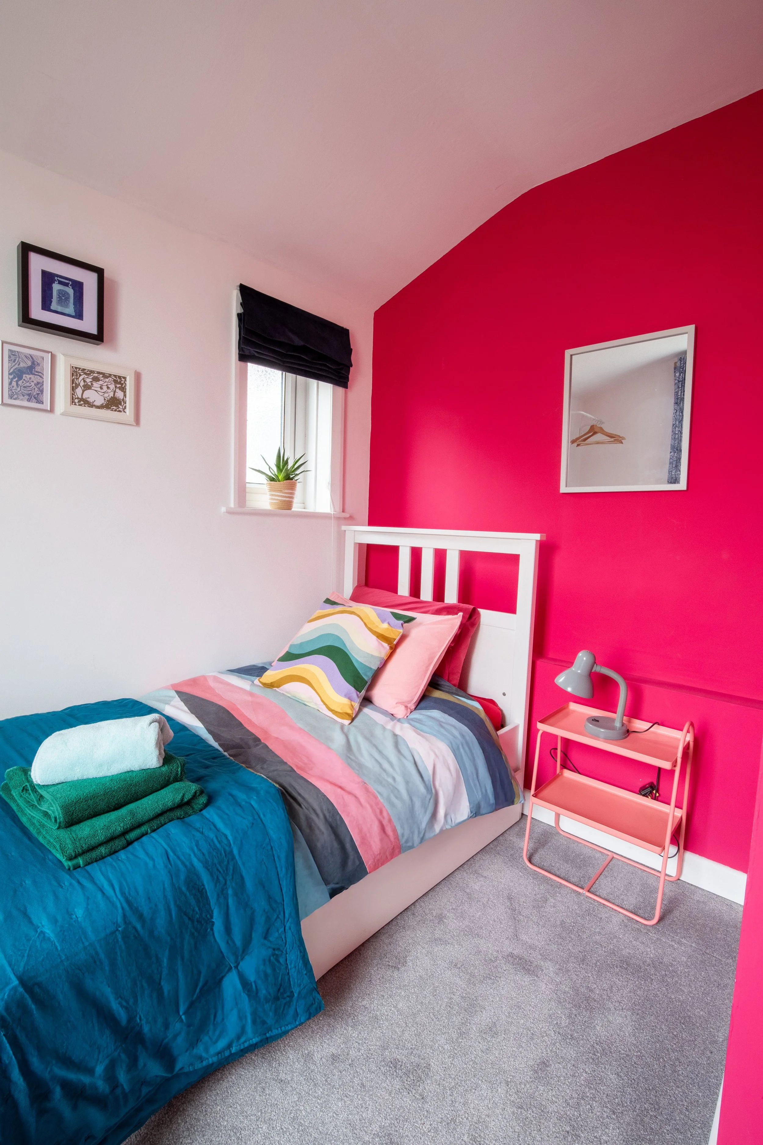 Small bedroom  with a comfortable single bed clothes storage, extra blankets, a bedside lamp. Compact and cosy