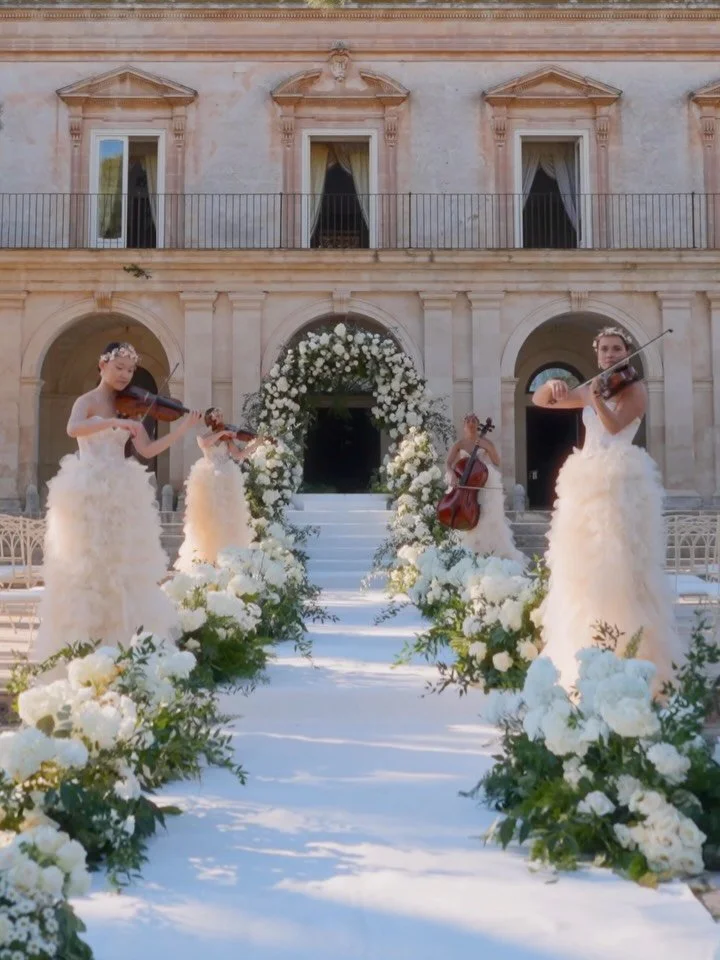 A moment suspended in time, where elegance meets emotion.

The bride&rsquo;s entrance becomes a true experience &mdash; a pathway of pure white florals, an architectural ceremony framed by refined symmetry, and the delicate harmony of live strings we