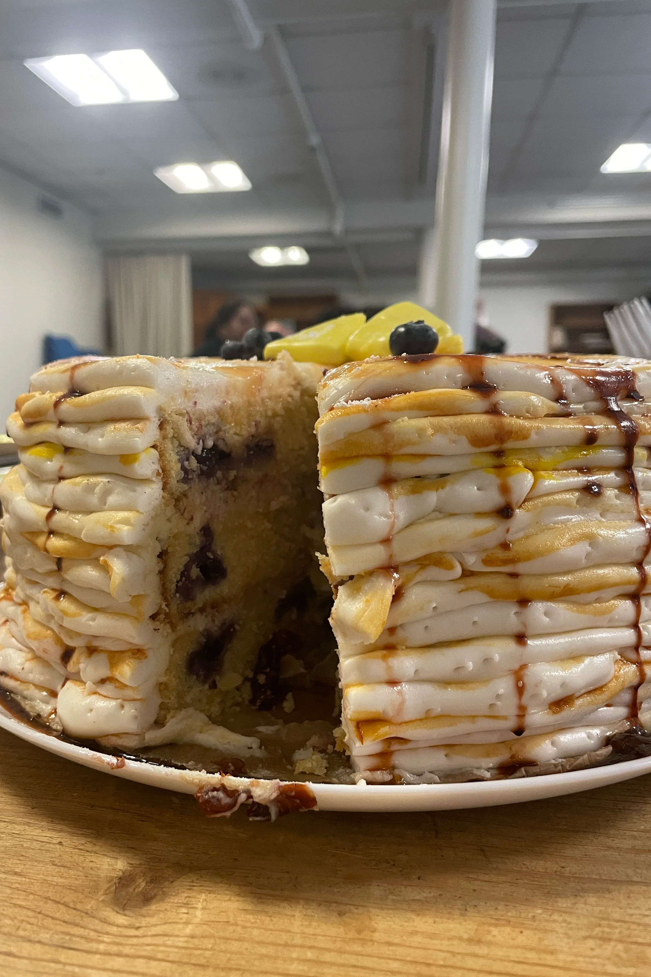 A cut into the Pancake Cake ("Pancake") reveals the lemon-blueberry layers inside - Merry Berry Confection Co, a micro-bakery specializing in holiday bakes and dessert bars for weddings and events near Raleigh, NC