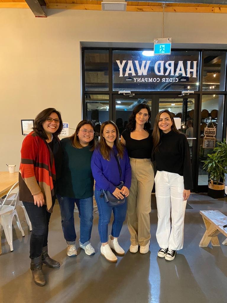 Five women standing together inside a restaurant called 'HARD WAY - CIDR COMPLANY', smiling at the camera.