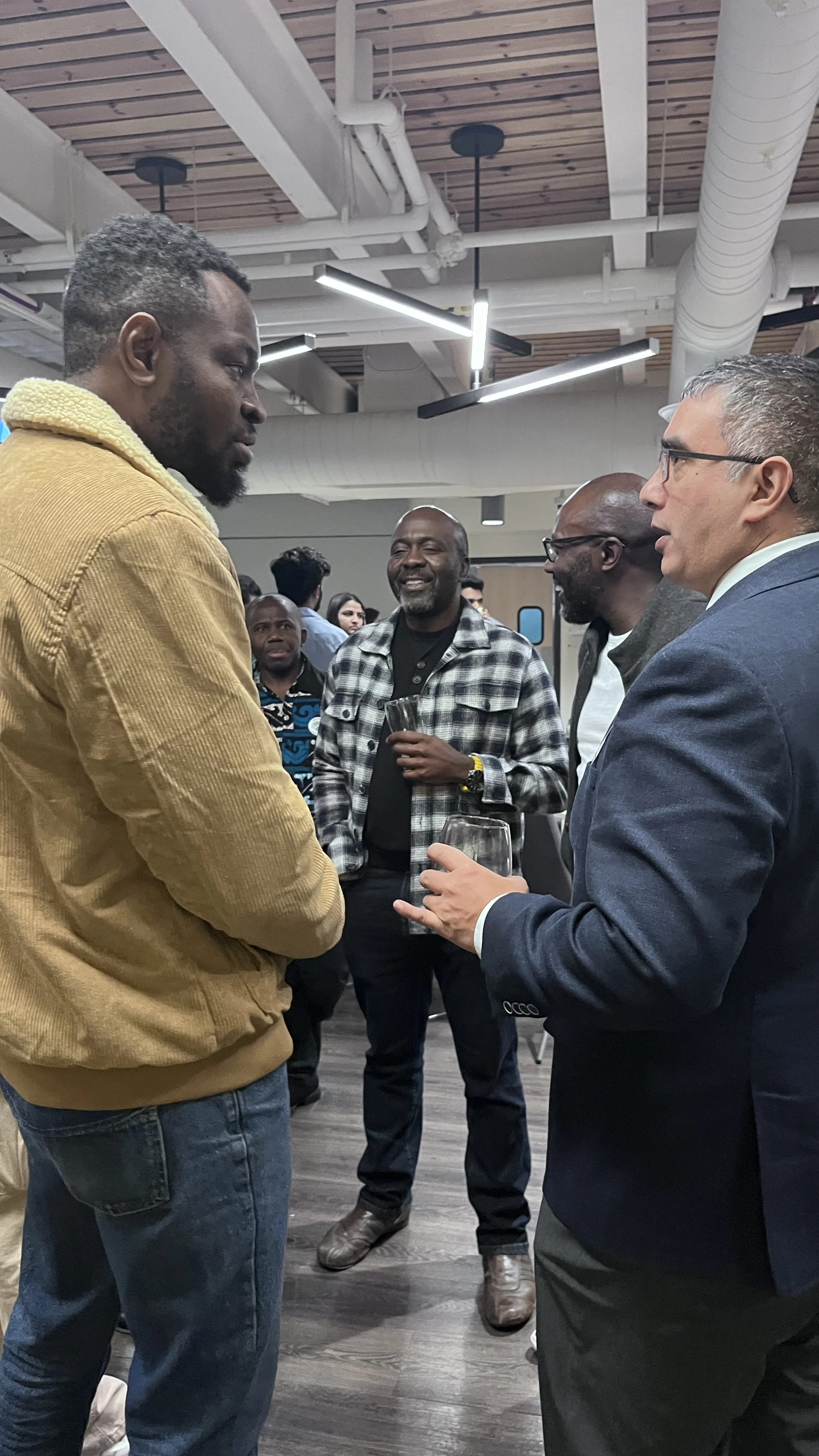 A group of people having a conversation at a social event indoors.