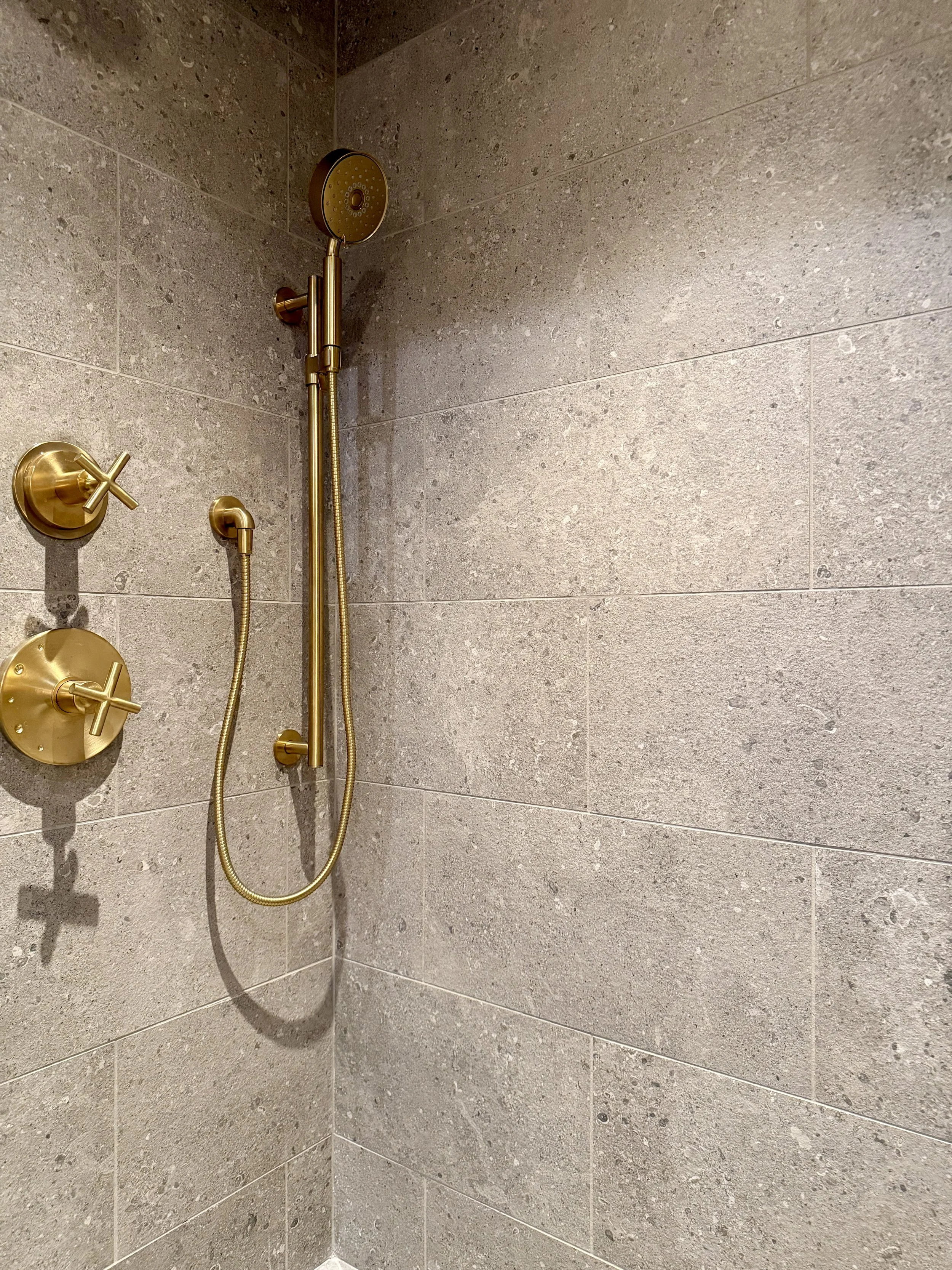 Architectural Details of Custom Built Steam Shower Including Schluter SHELF-W in Wave Greige, 1/2" Clear Glass & 1/2" Brushed Gold Structural Channel.

Steam Generator Control and Purist Body Spray in Vibrant Brushed Moderne Brass by Kohler. 

Thermo