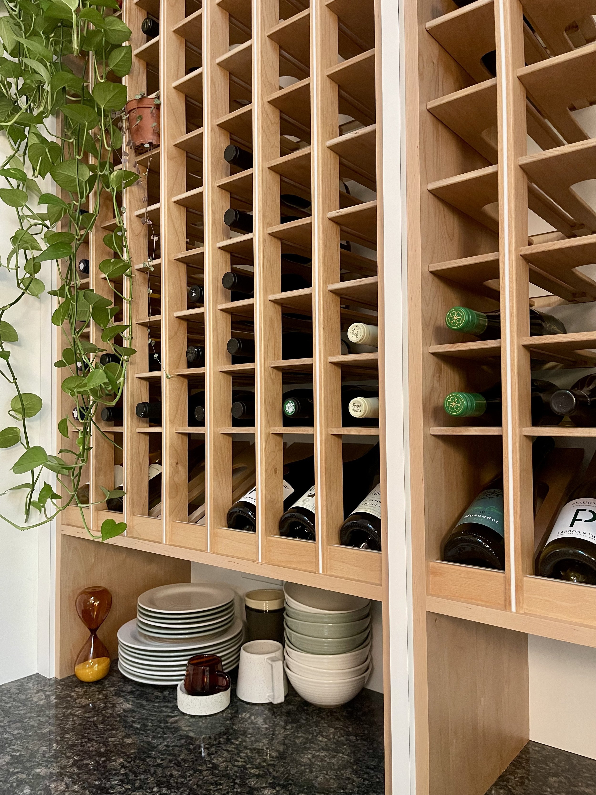 Kitchen countertop wine storage unit in Alder with white epoxy inlay and angular wine display area.

Wine Cellar project completed in Northville MI.