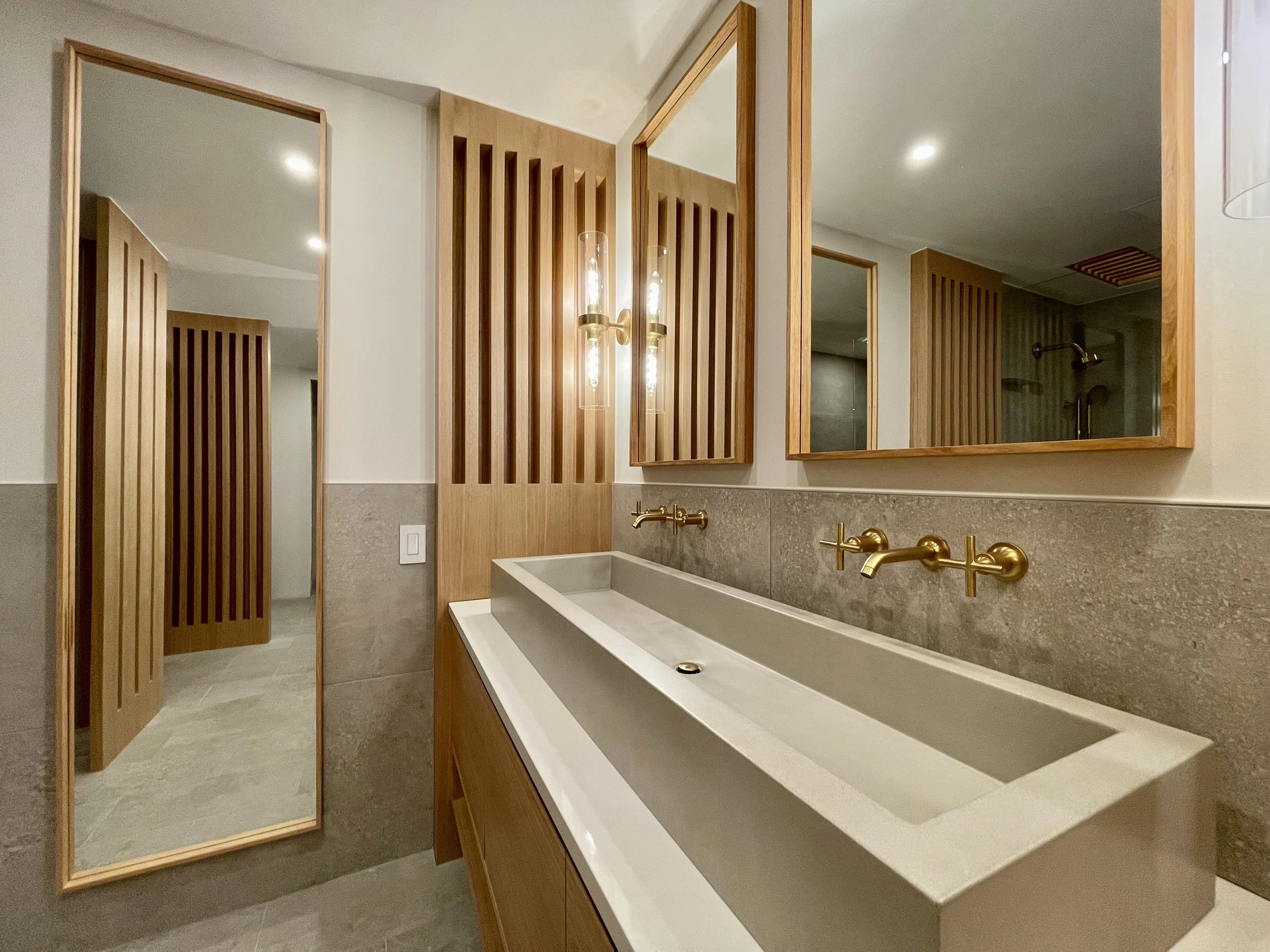 Architectural Details in Uniform Hickory Veneer and Hickory Heartwood Finished with Centurion 2K Polyurethane.

Wall Mounted Fixtures are Kohler Purist in Vibrant Brushed Modern Gold. 

TrueForm Custom Concrete Sink in Taupe

Scandinavian Inspired Ba