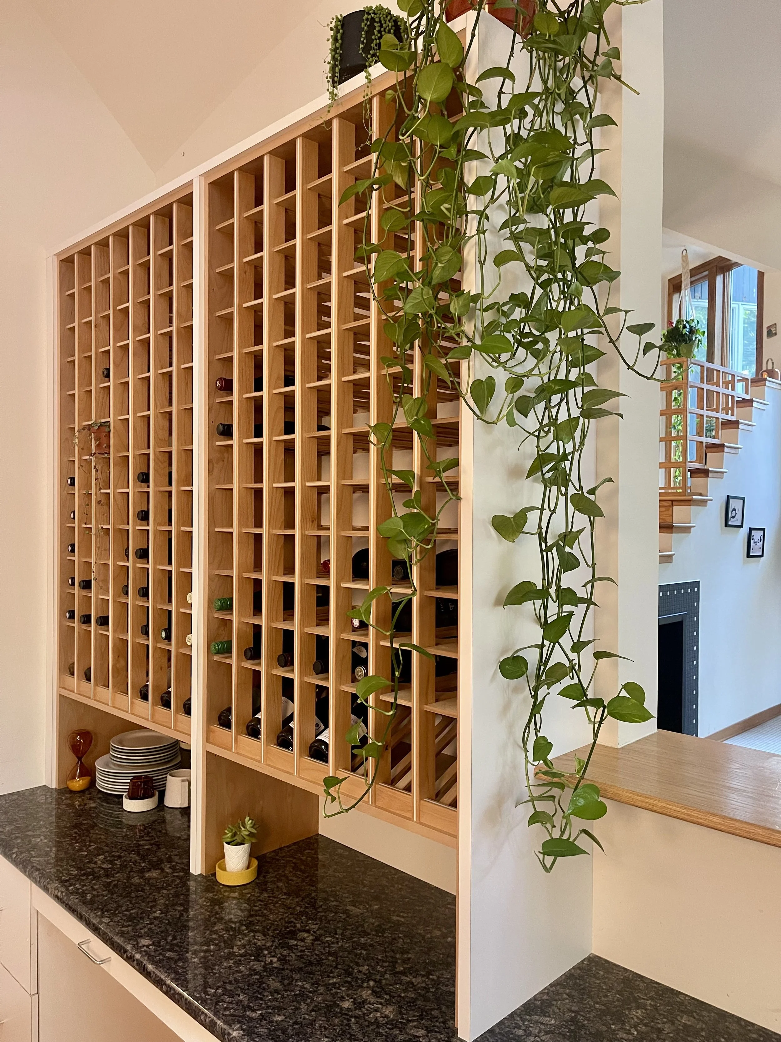 Kitchen countertop wine storage unit in Alder with white epoxy inlay and angular wine display area.

Wine Cellar project completed in Northville MI.