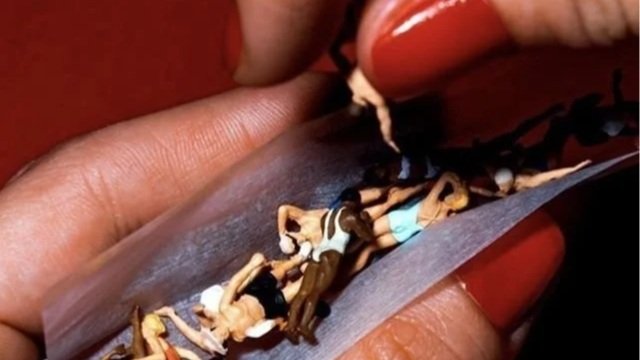 Frauenhand arrangiert erwachsene Miniaturfiguren in einem Joint-Blättchen – Sinnbild für einen bewussten, erwachsenen Cannabis Lifestyle.