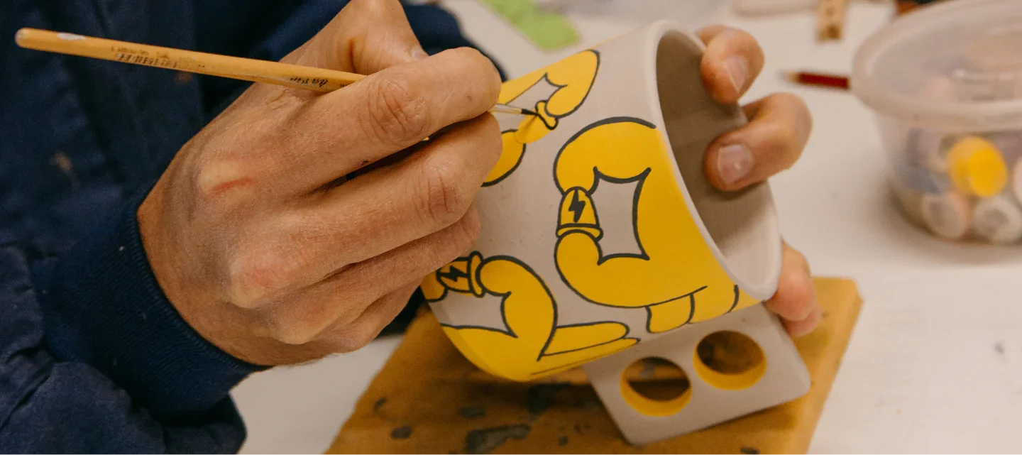 Minx >Gründer bemalt gerade von hand eine kermaik tasse mit urbanen grafitti mustern aus den eigenen designs.