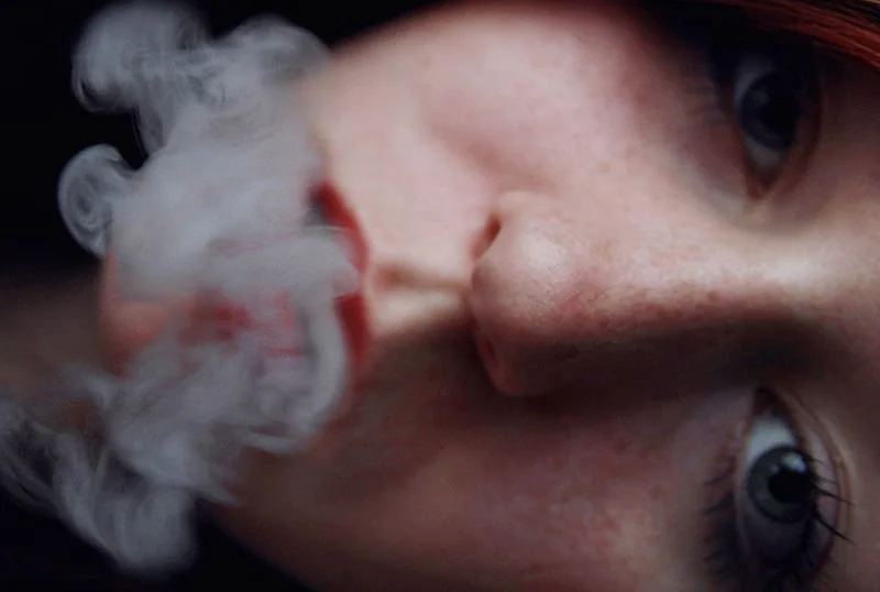 ein junges berliner mädchen pustet diskret cannabis rauch aus dem mund aus und genießt es sichtlich