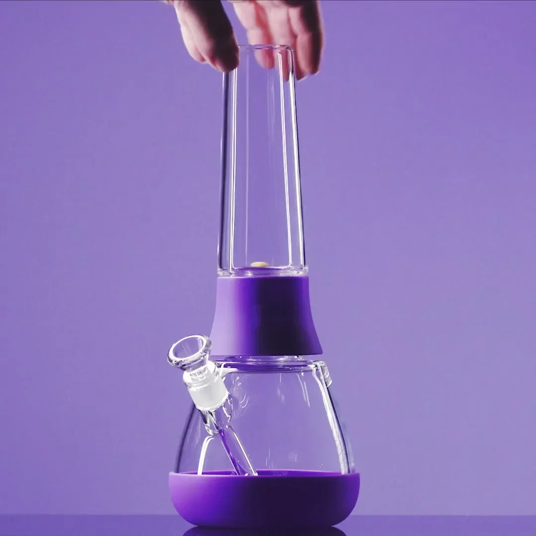 Minimalistisches Lifestylefoto: Hand hält Weeday Bong in Grape vor farbigem Hintergrund.