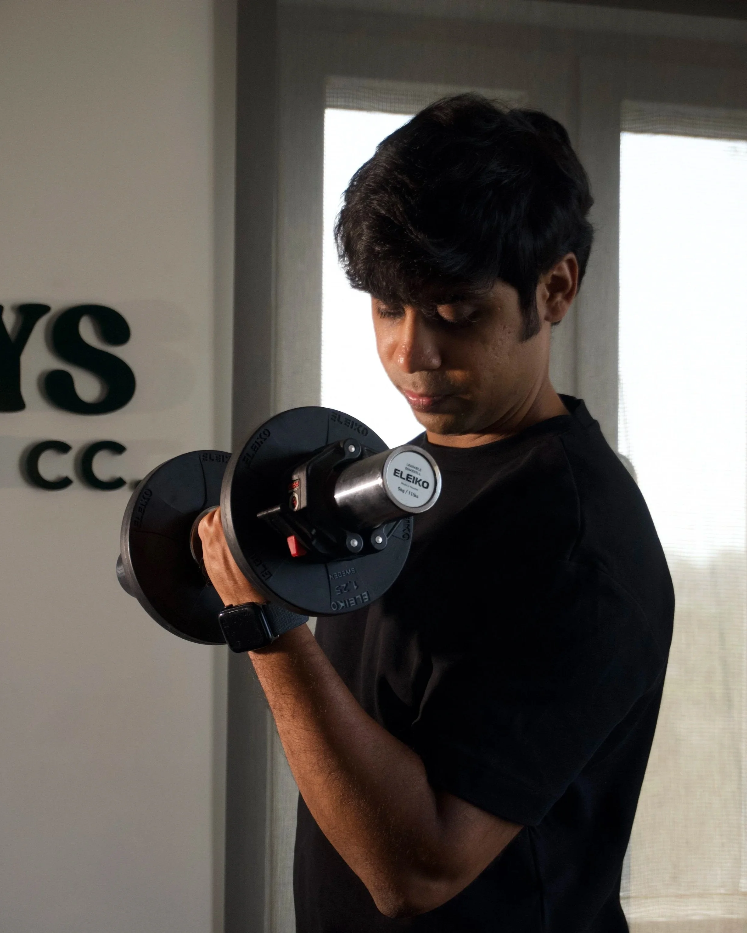 Personal trainer Chirag Chordia performing a dumbbell bicep curl during a workout session.
