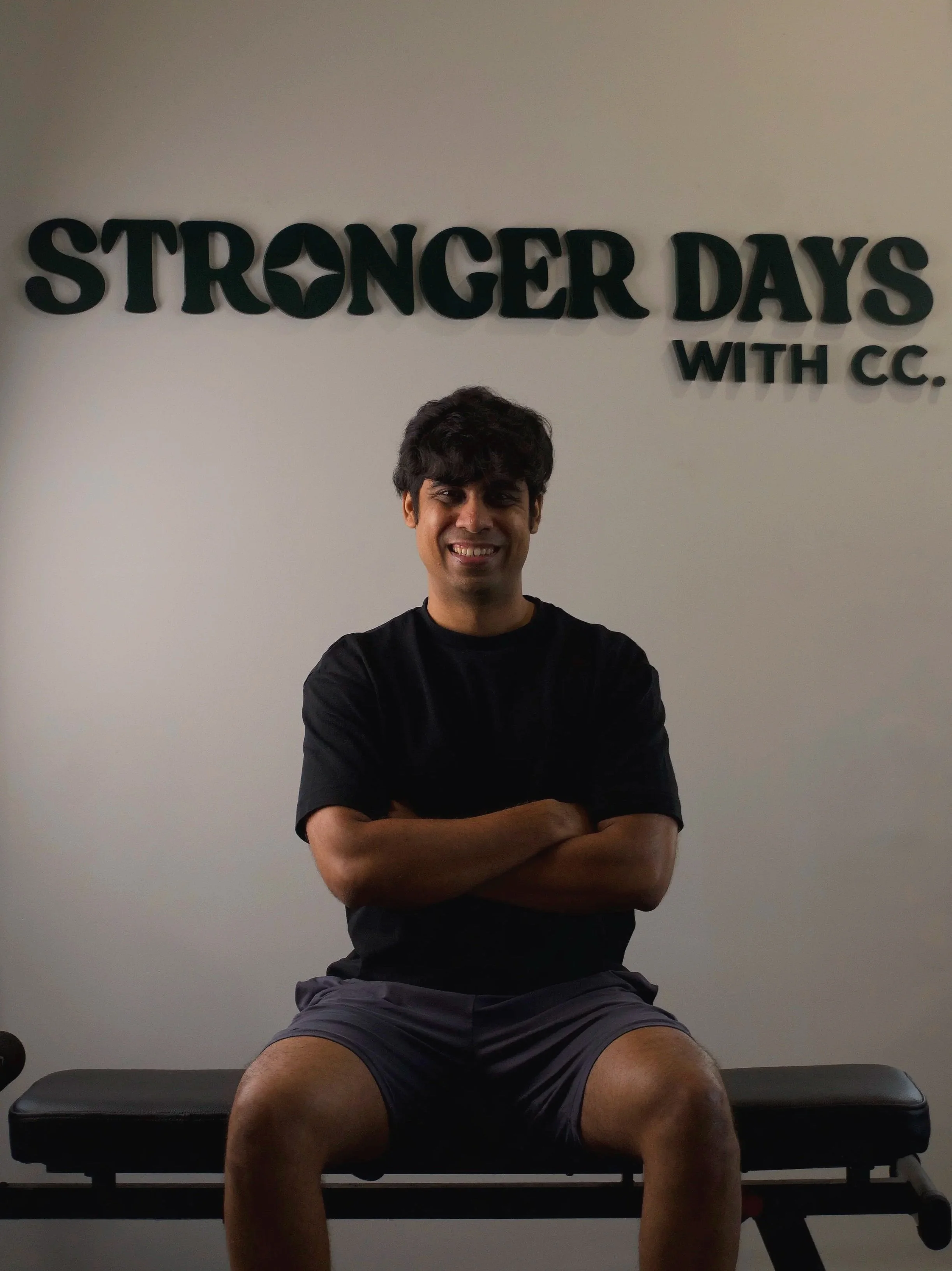 Chirag Chordia sitting on a gym bench in front of the Stronger Days with CC logo text.