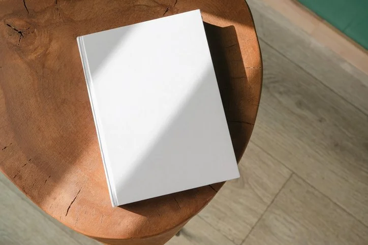 Blank white notebook on wooden table.