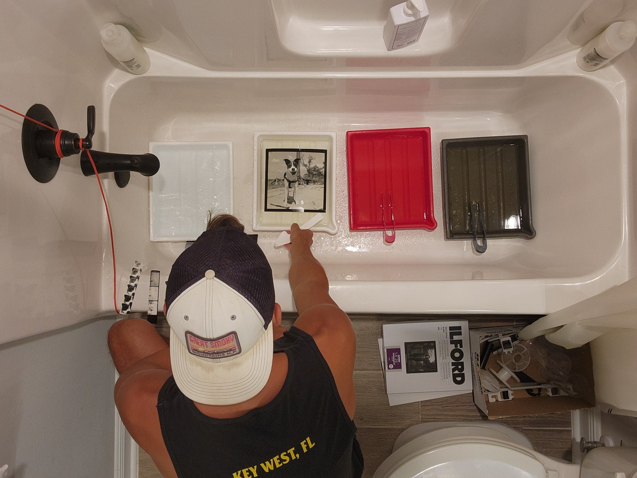 Tyler Wilson making a photograph in his darkroom.  The photograph is of a dog at the beach.