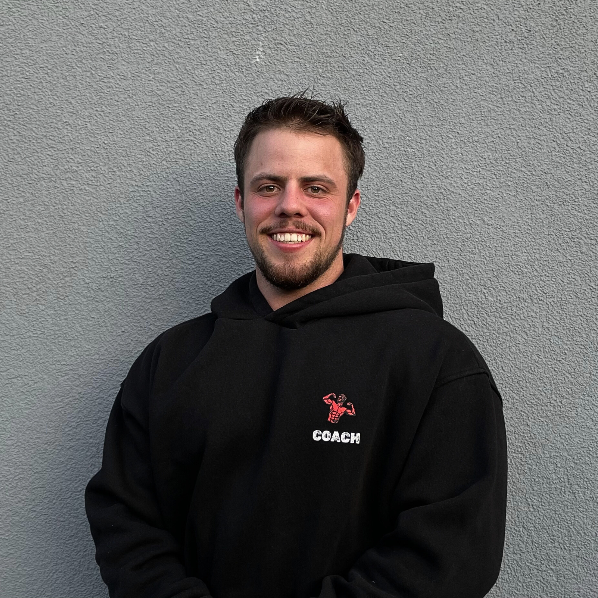 Coach Jakob von PeakAestheticsCoaching in gebrandeter Kleidung – professionelle Betreuung im Kraftsport und Bodybuilding.