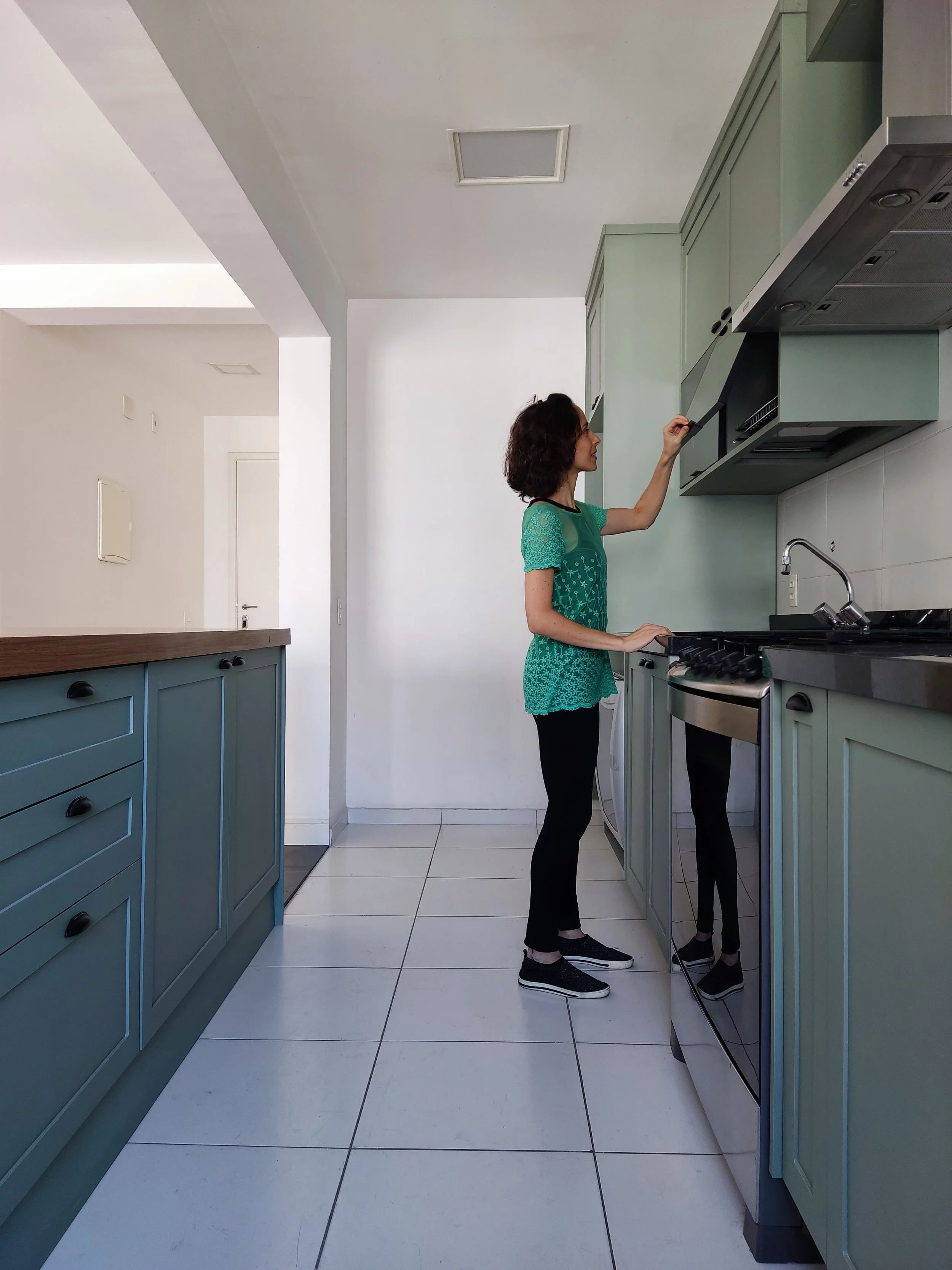 Mulher arrumando o móvel no armário cozinha