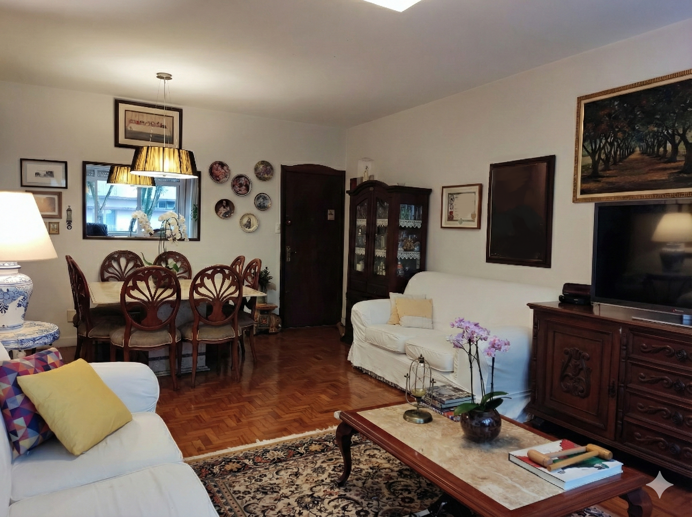 Sala de estar e jantar com sofás brancos, mesa de jantar de madeira com cadeiras, armário com vidro, televisão, quadros e tapete.