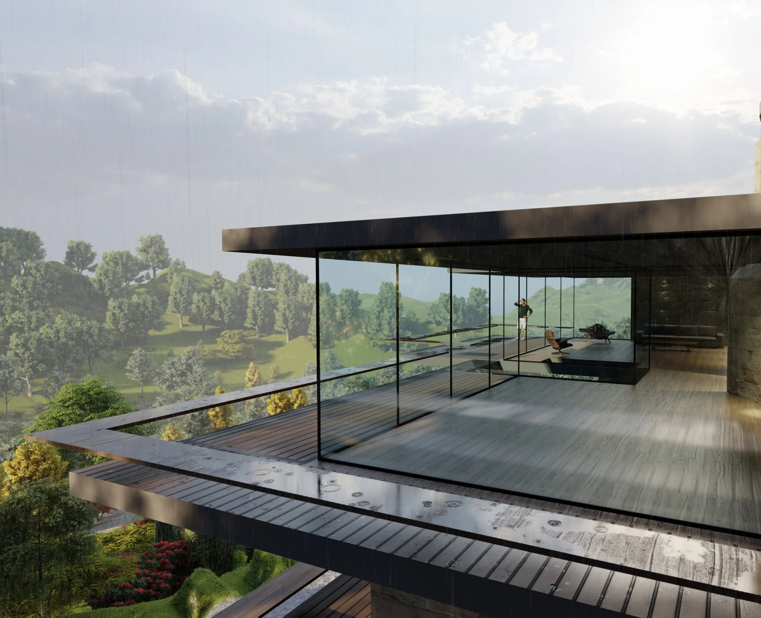 Modern glass-walled house on a hillside overlooking green trees and rolling hills with clouds overhead, featuring a rooftop terrace with wooden flooring and a person looking out from the interior.