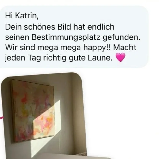 Ein helles, abstraktes Gemälde mit warmen Farben an einer Wand, im Sonnenlicht.