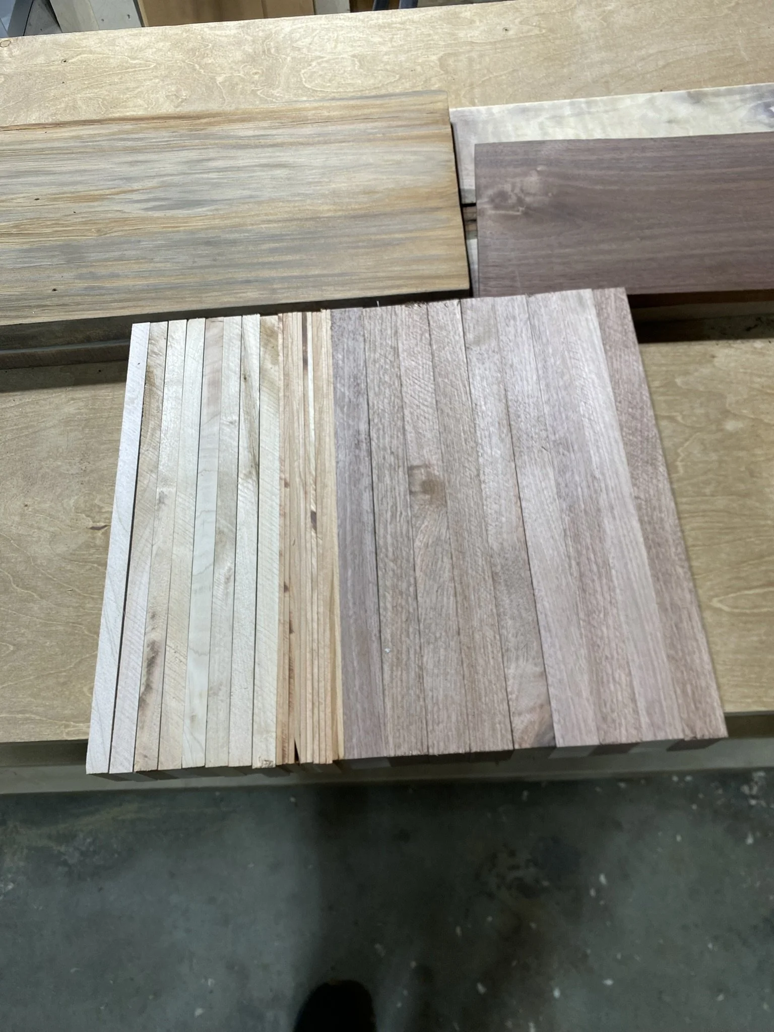 Various wood sample panels on a workbench, showing different grain patterns and colors.