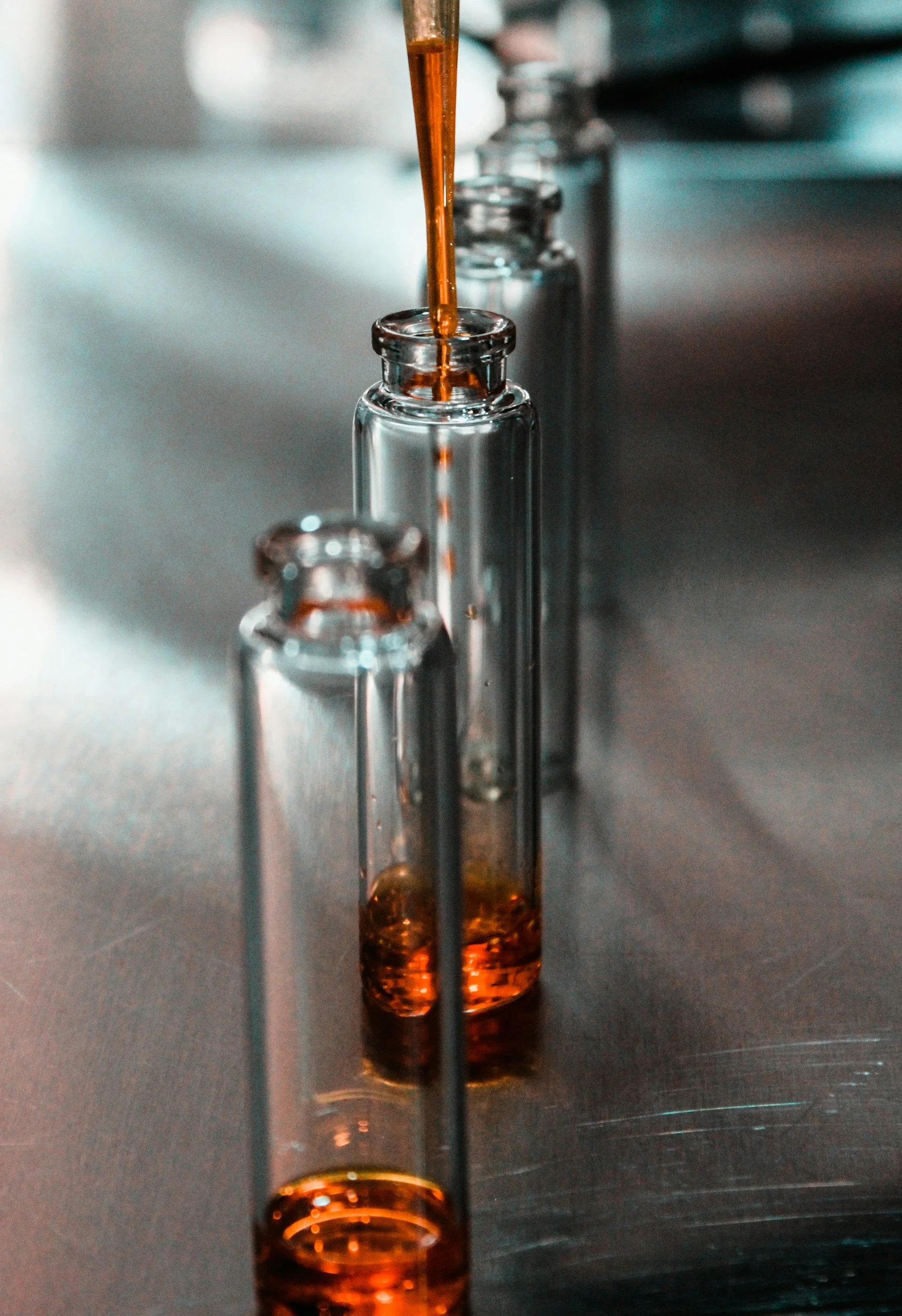 Test tubes with orange fragrance being filled in a laboratory setup.