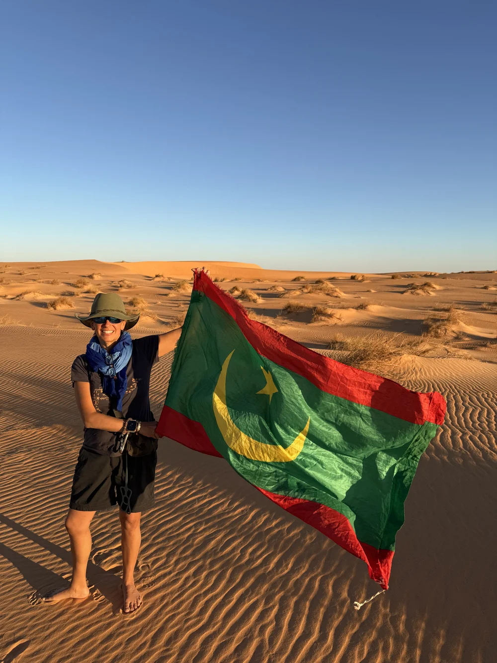 Holding the Mauritanian flag in the dunes