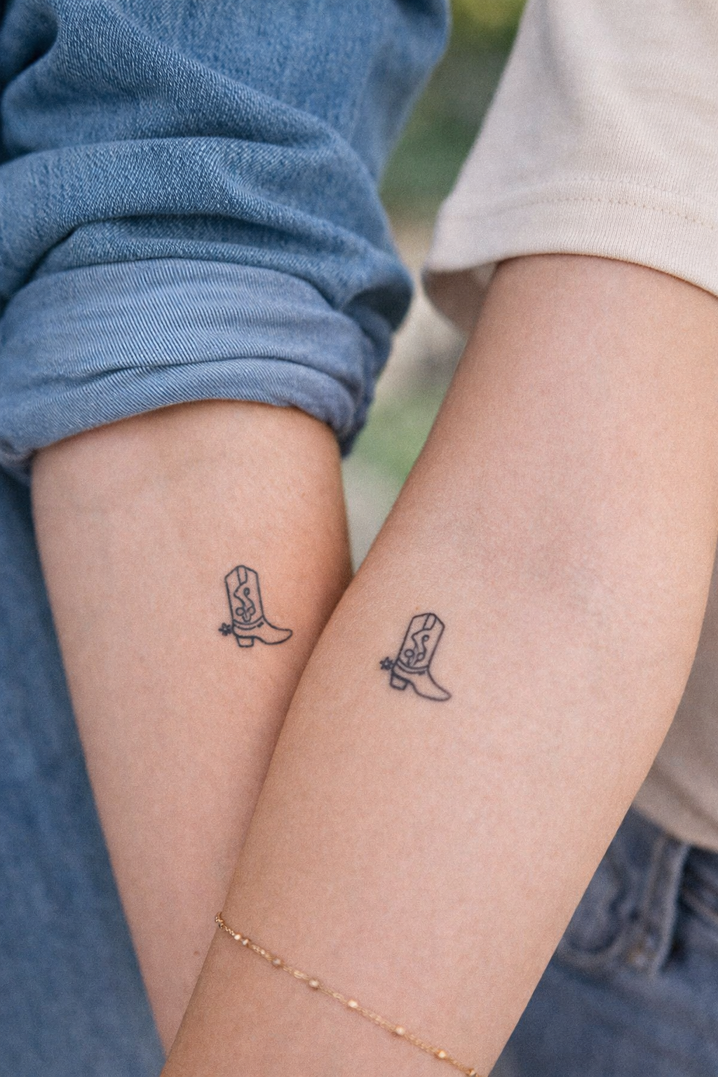 Two people with matching tattoo of a cowboy boot with a dollar sign on the side.