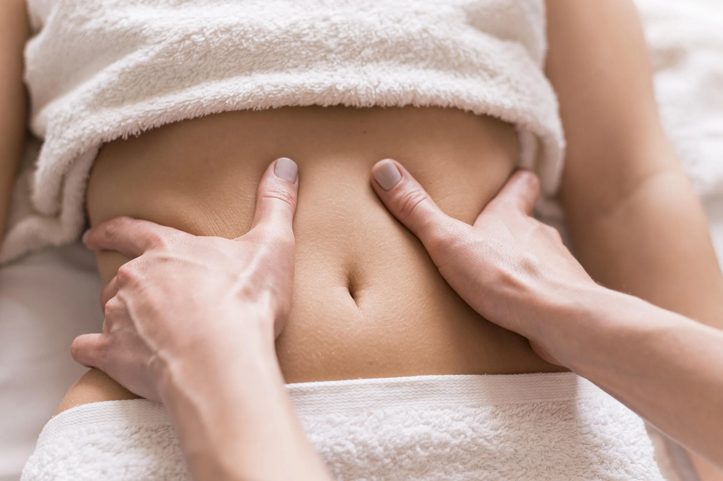 Photo d'un massage du bas ventre et des flans selon la méthode Vodder en drainage lymphatique