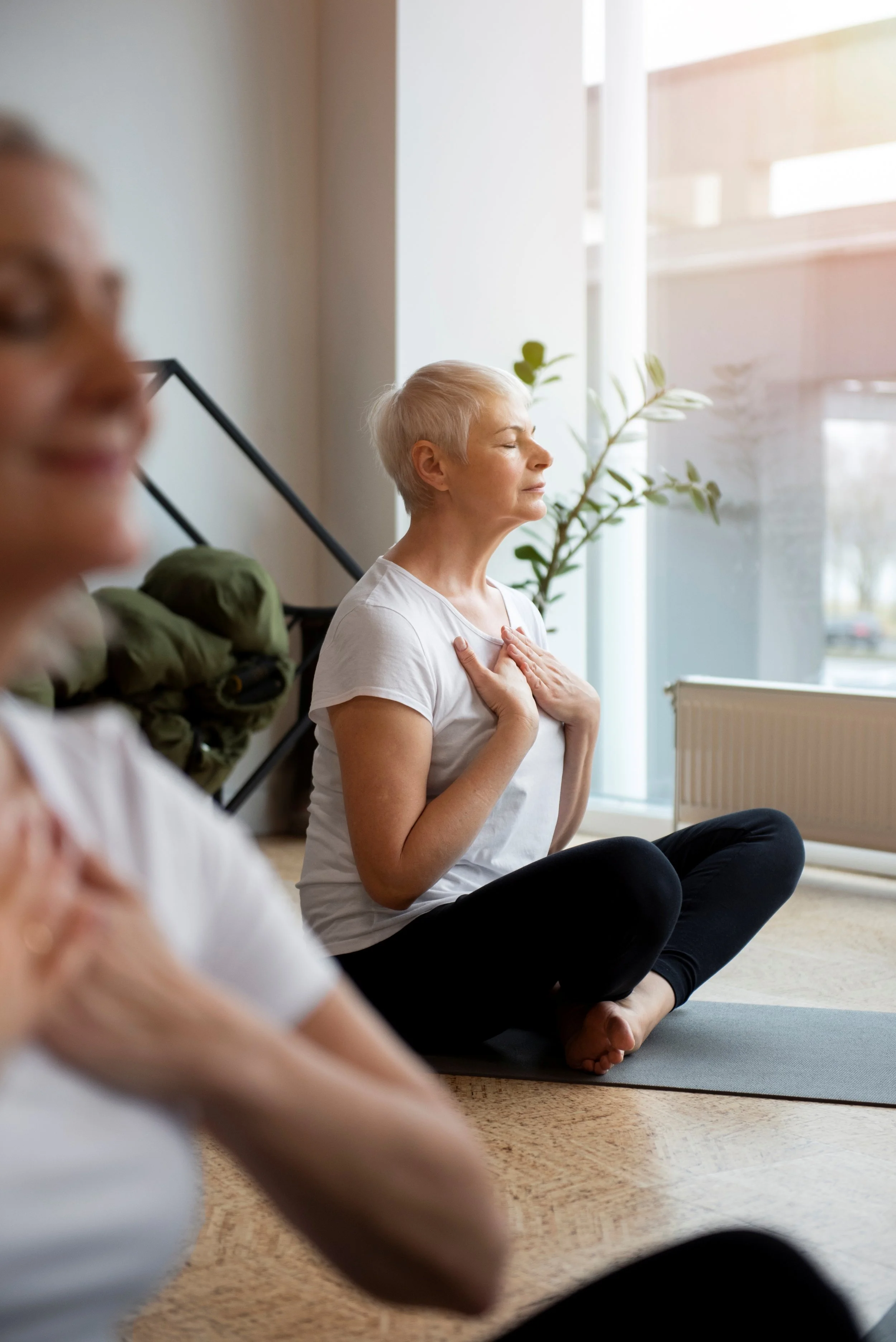 Photo d'une femme assise pendant une séance de sophrologie, pratiquant la relaxation, la respiration guidée et la visualisation positive