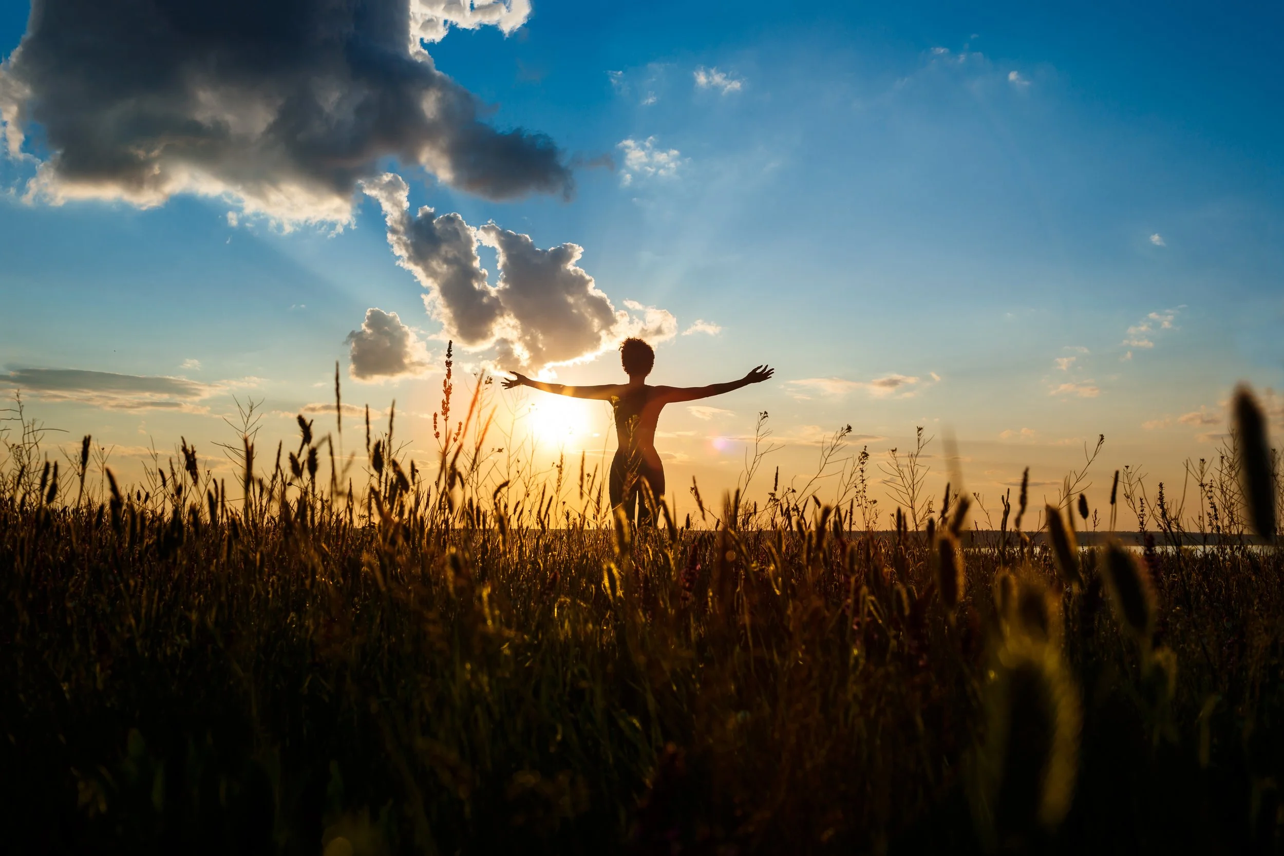 Photographie d'une femme pratiquant la sophrologie au lever du soleil, illustration du bien-être et de l'énergie apportés par la sophrologie
