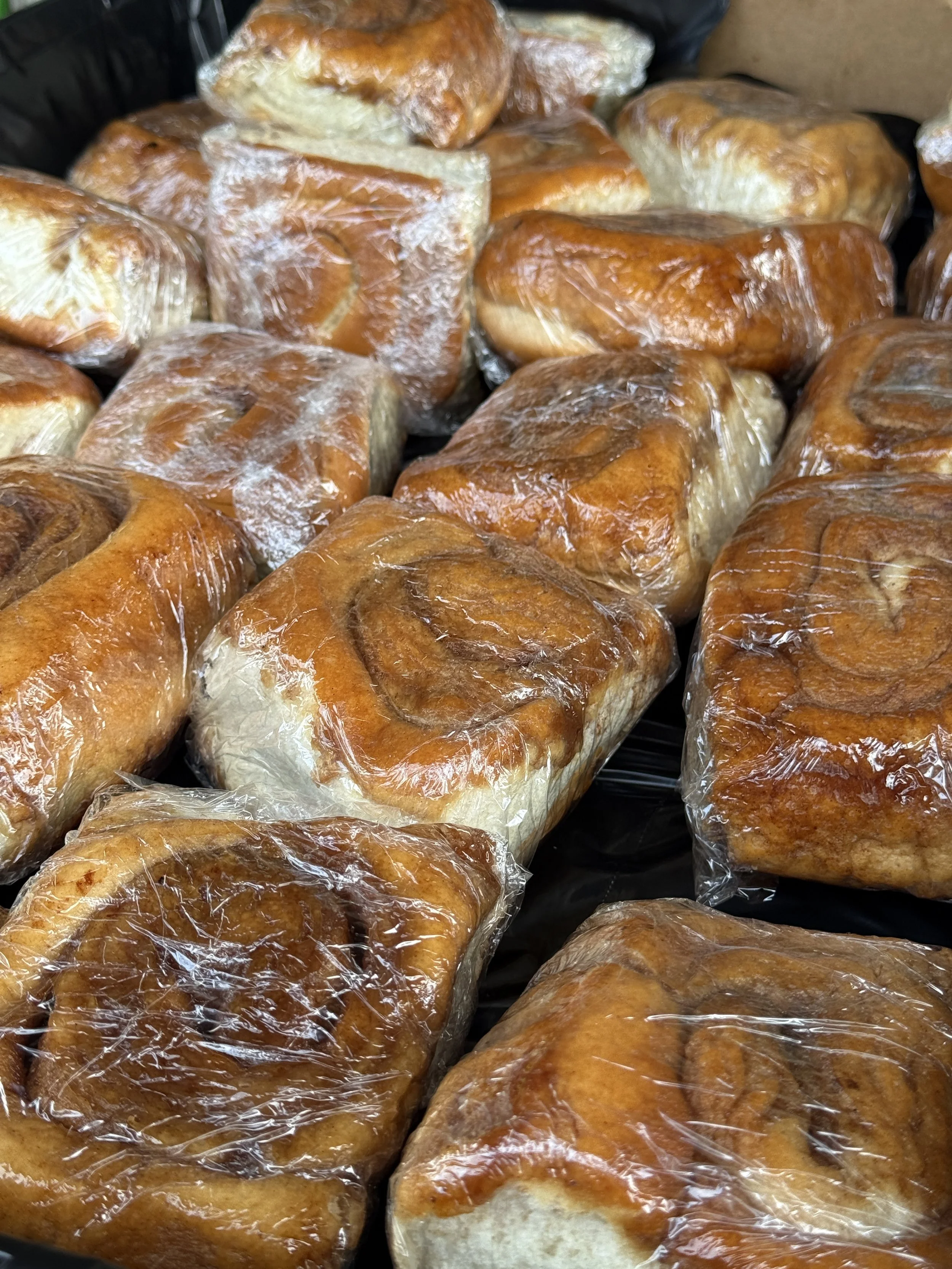 Several cinnamon rolls wrapped in clear plastic.