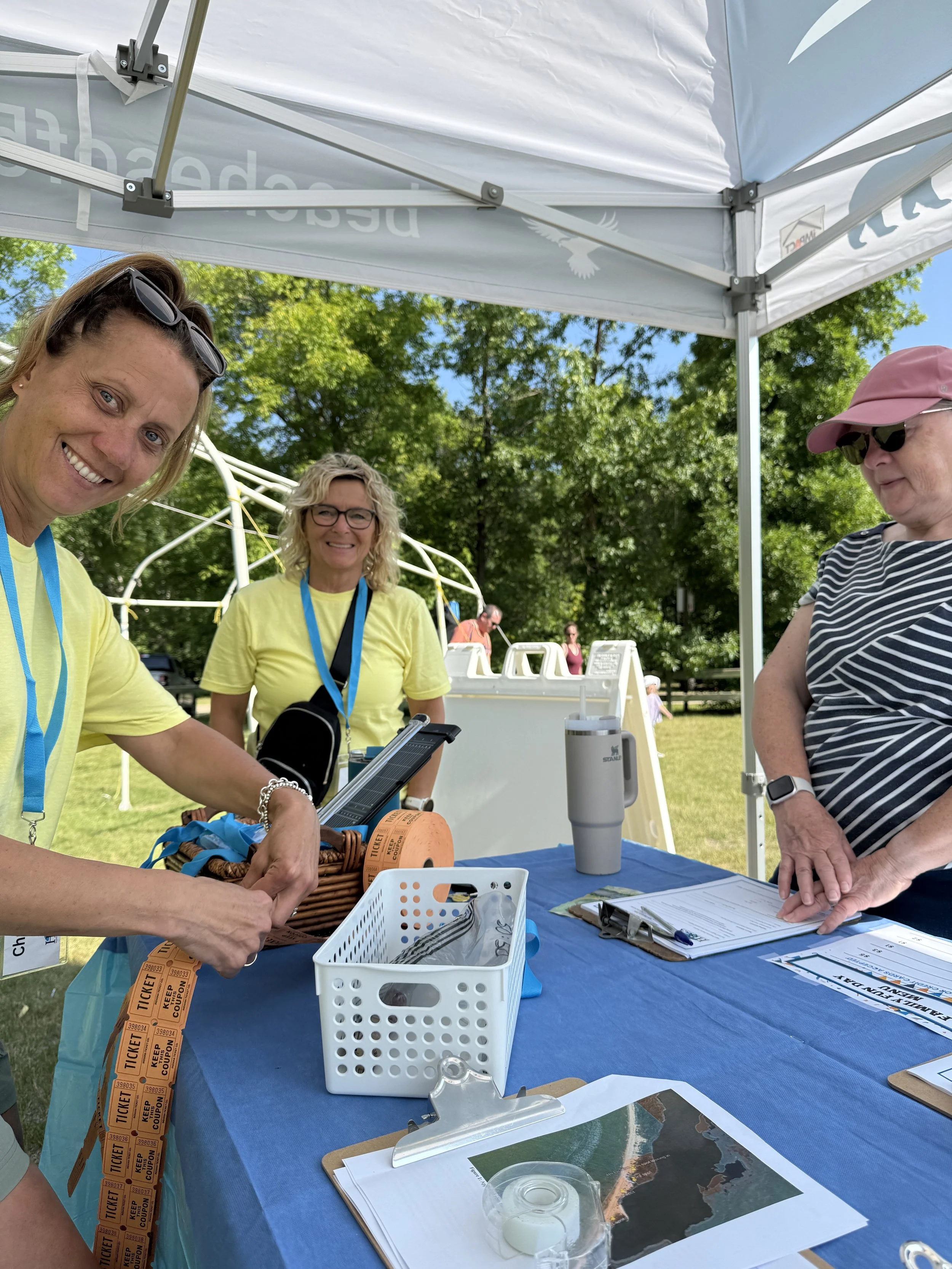 Volunteers at the HBCA Family Fun Day registration table selling memberships and 50:50 tickets