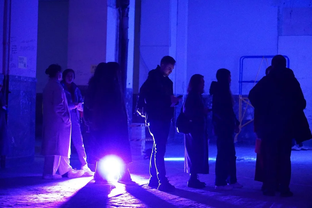 Close-up of shallow beach water with ripples and two small rocks visible on the sandy bottom.