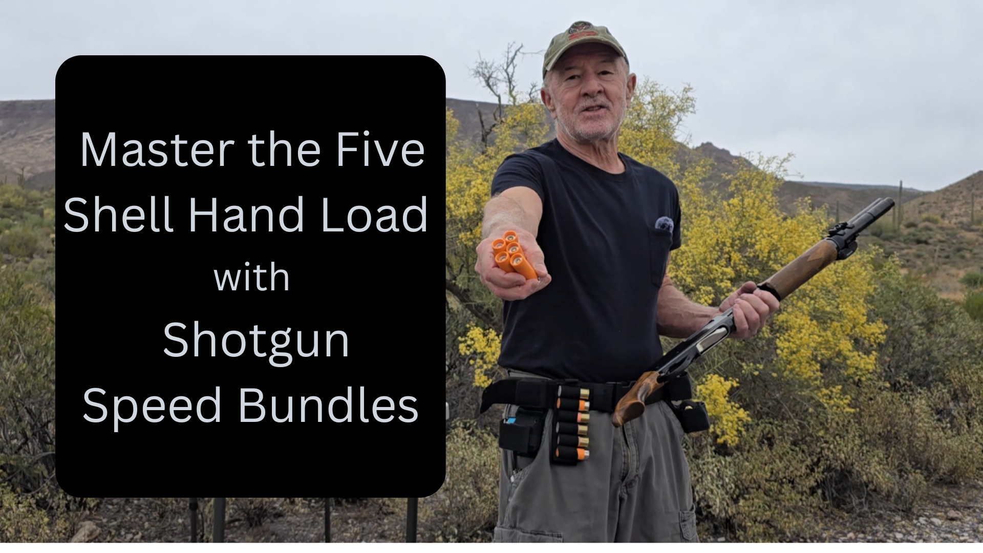 A man outdoors in a desert landscape, holding a shotgun with shells in his hand, wearing a cap and cargo shorts, with yellow flowering bushes and mountains in the background, promoting gun safety.