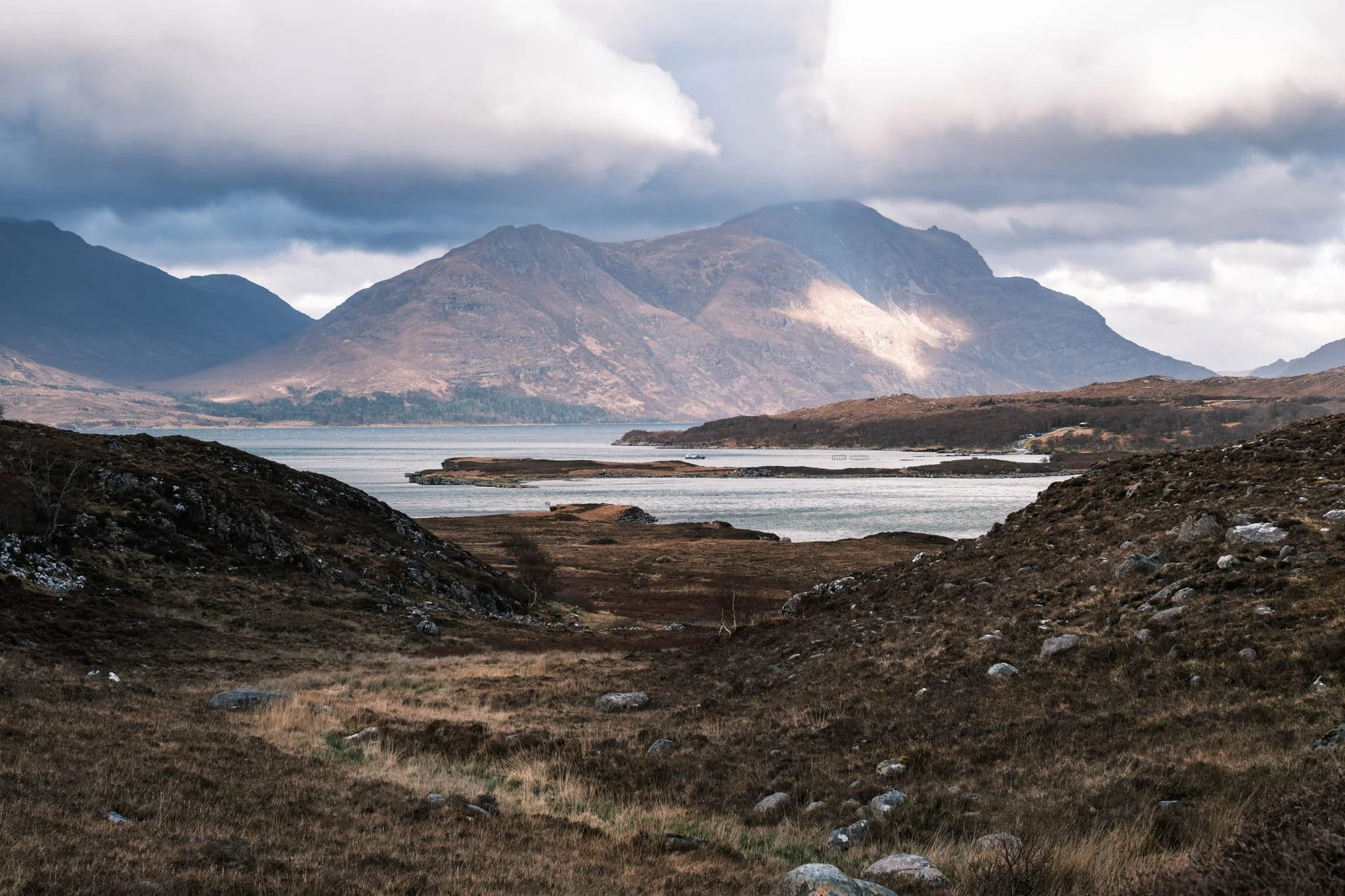 Highland - Scotland - Paysage de montagnes avec un Loch au premier plan, ciel nuageux.