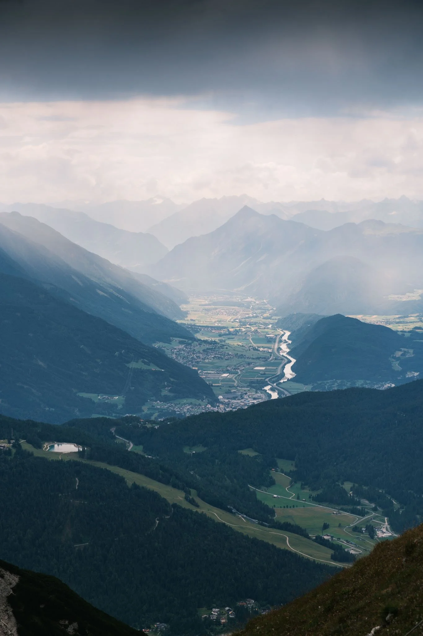Tyrol - Paysage montagneux avec vallée, forêt, rivière et nuages dans le ciel. Reportage outdoor, mise en valeur du territoire et tourisme durable par Guillaume Donsimoni