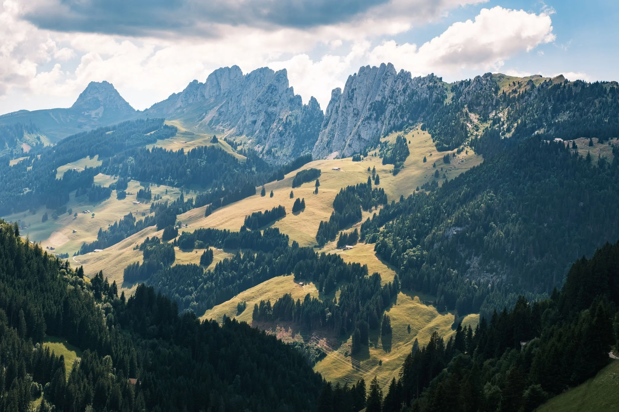 Austria - Paysage de montagnes avec forêts et collines verdoyantes sous un ciel nuageux. Reportage outdoor, mise en valeur du territoire et tourisme durable par Guillaume Donsimoni