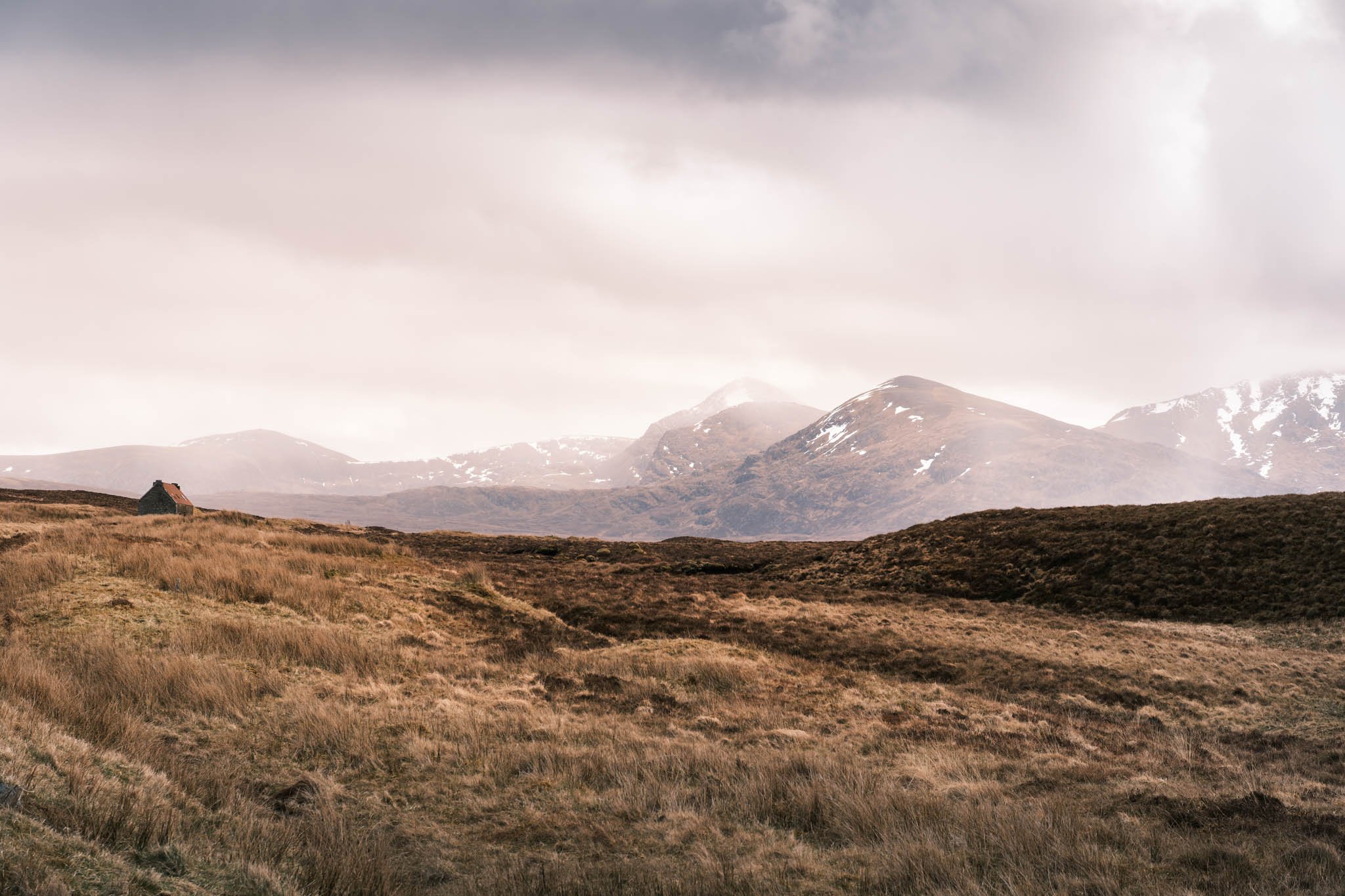 Highland - Scotland - Paysage de montagne avec une cabane en bas à gauche.