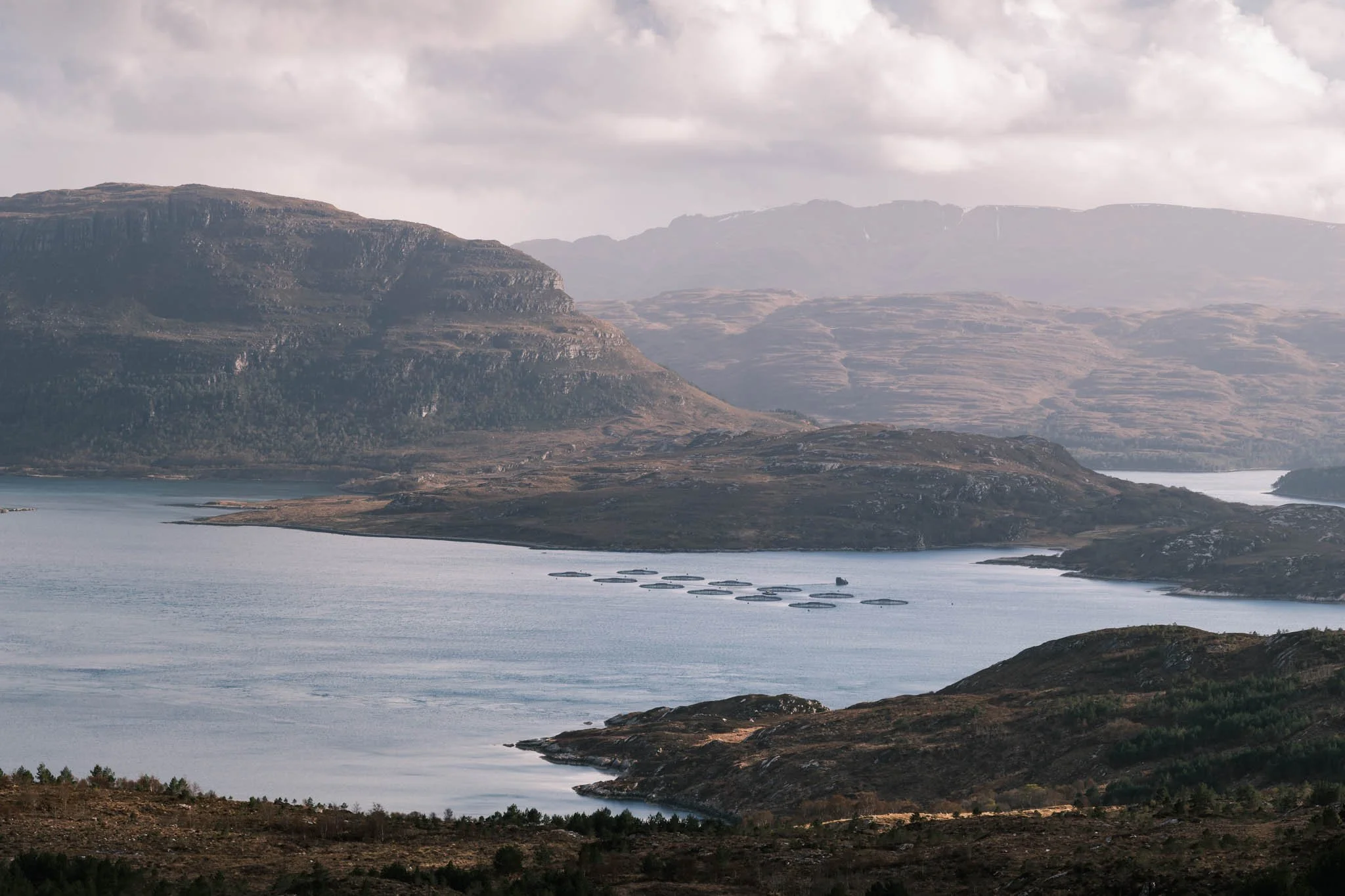 Highland - Scotland - Paysage de montagnes avec un Loch au premier plan et des nuages dans le ciel.