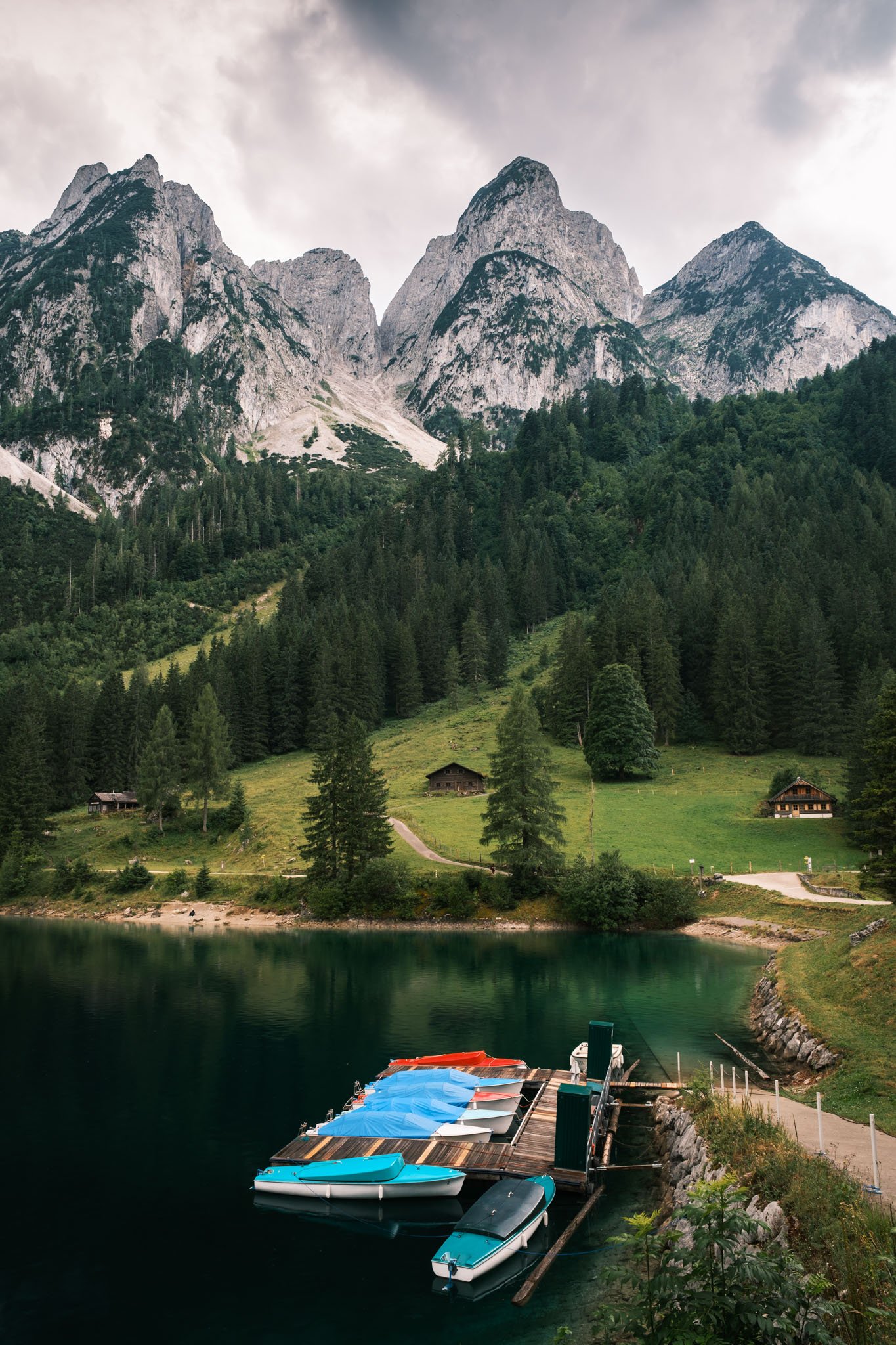 Austria - Montagnes avec sommets rocheux, forêt dense, maison en bois, lac avec bateaux et jetée en bois. Reportage outdoor, mise en valeur du territoire et tourisme durable par Guillaume Donsimoni
