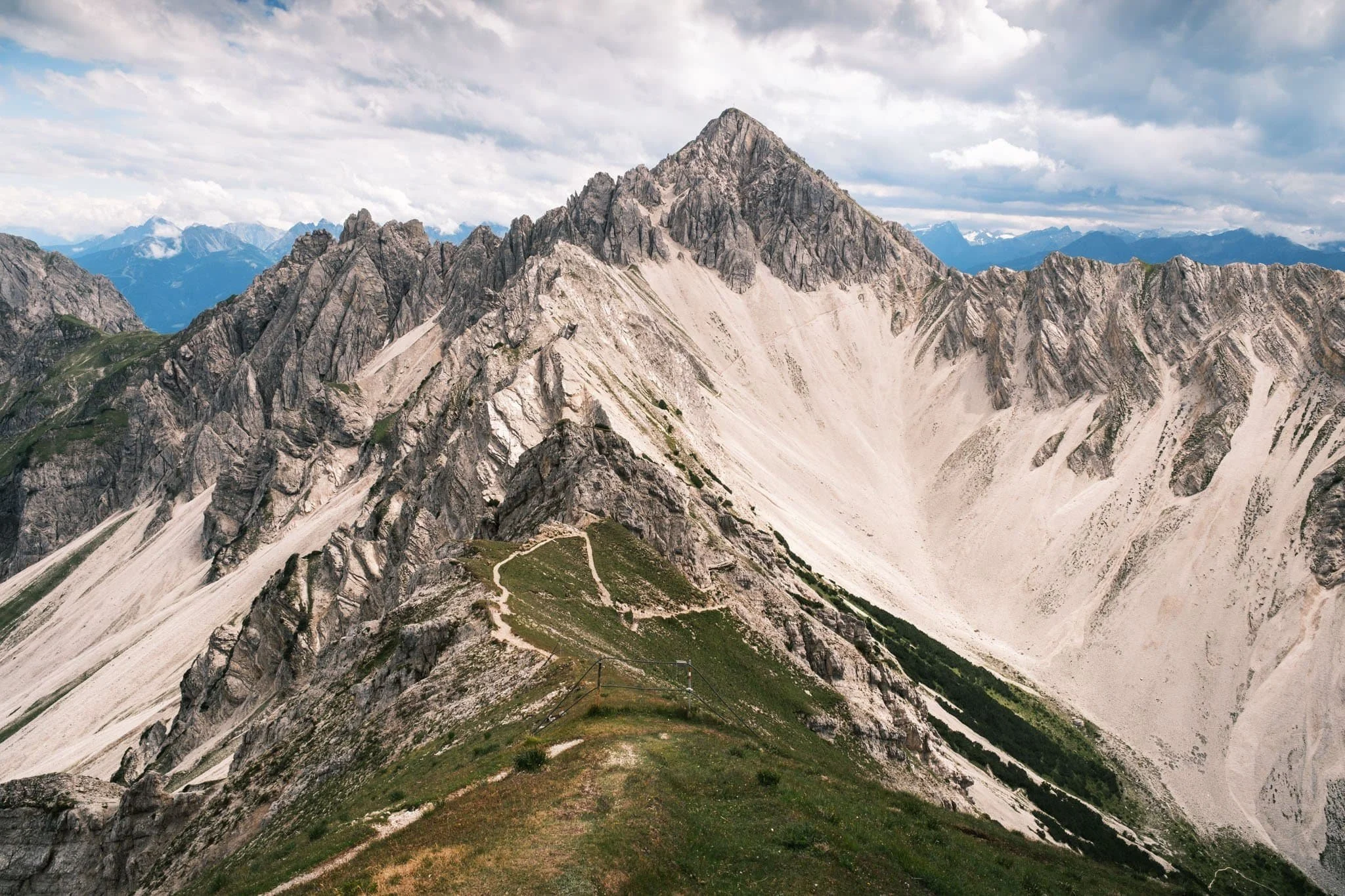 Photographie de montagne, sentier de crête et perspective sur les sommets de l'Alpe.