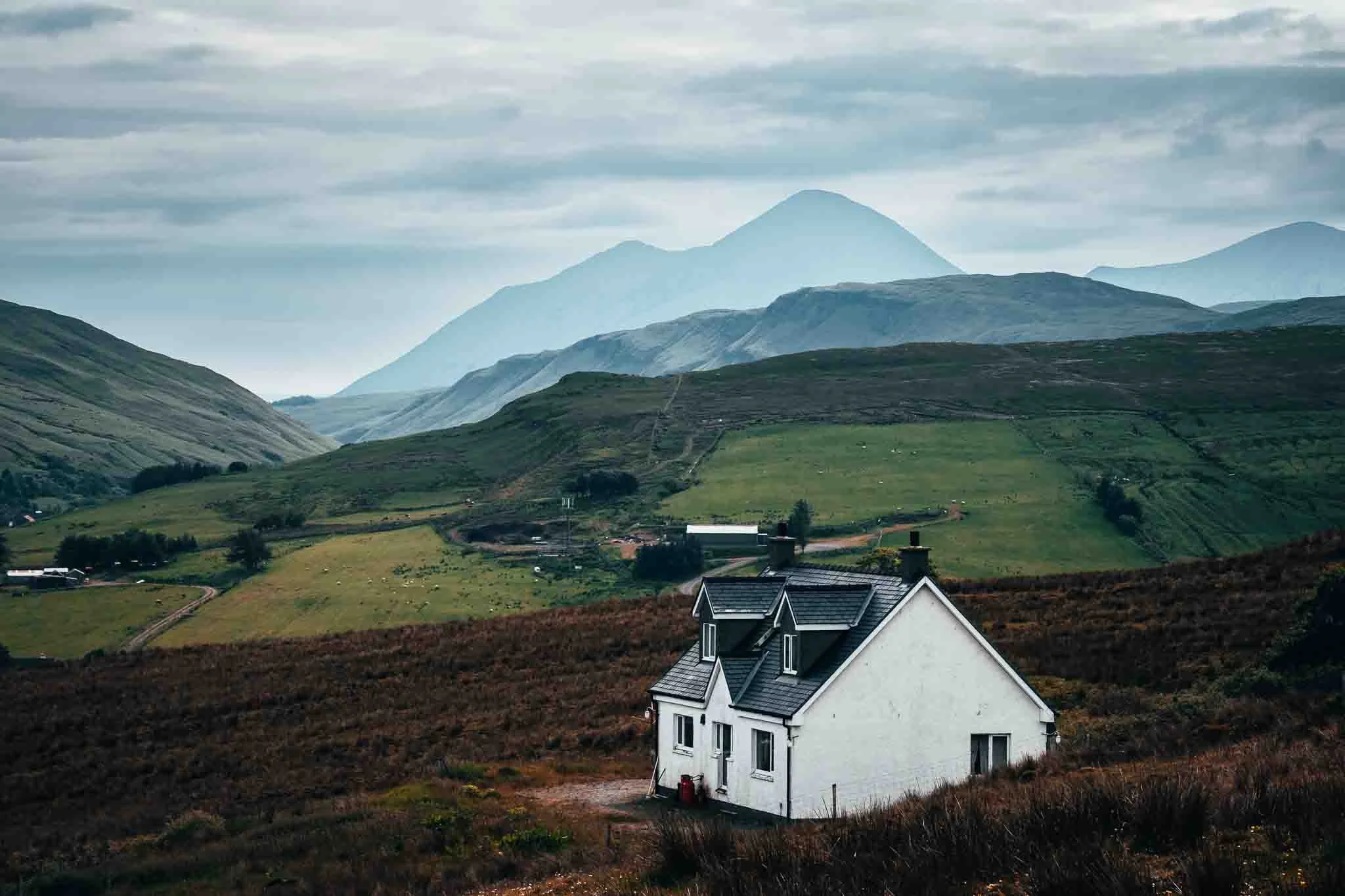Maison blanche traditionnelle isolée dans les montagnes des Highlands - Concept de slow tourism et d'immersion territoriale en Écosse.